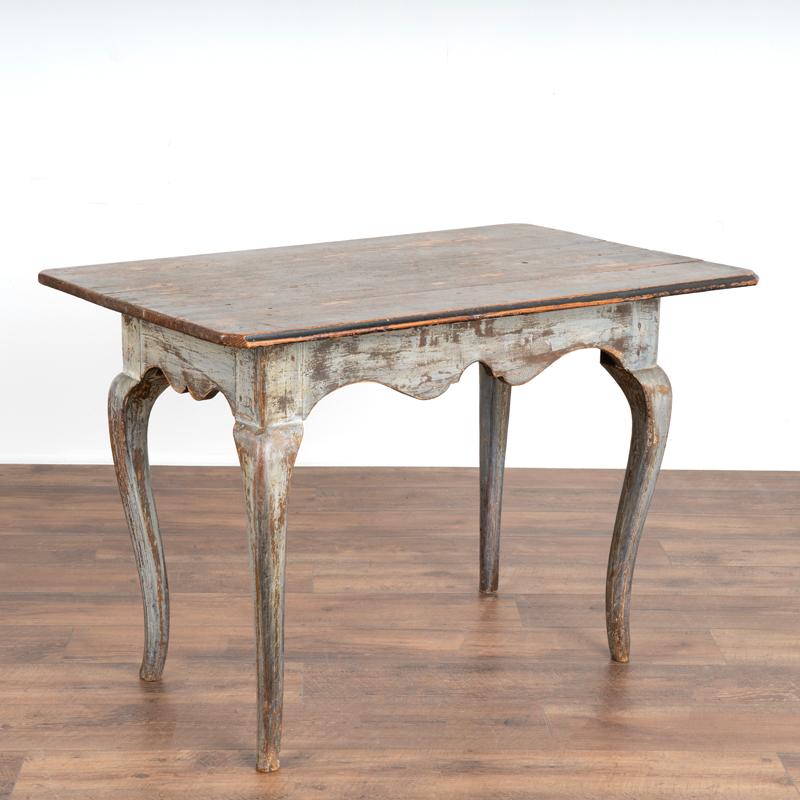 It is the original soft gray painted finish and gently curved cabriolet legs that attract attention in this endearing Swedish gustavian side table. The paint had been gently distressed through generations of use which instills an aged grace to the