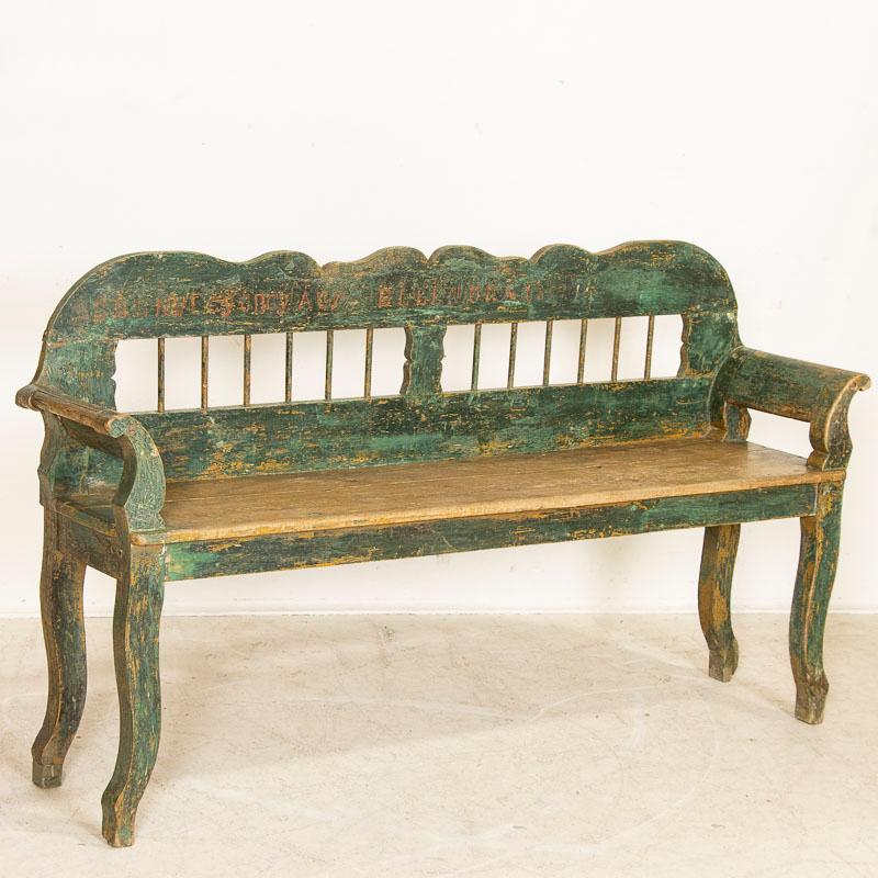 This bench is loaded with character, and almost whispers the stories that have been told while sitting upon it. The original and naturally distressed green paint remains with names still seen faintly in red paint, along with the date of 1897. Please