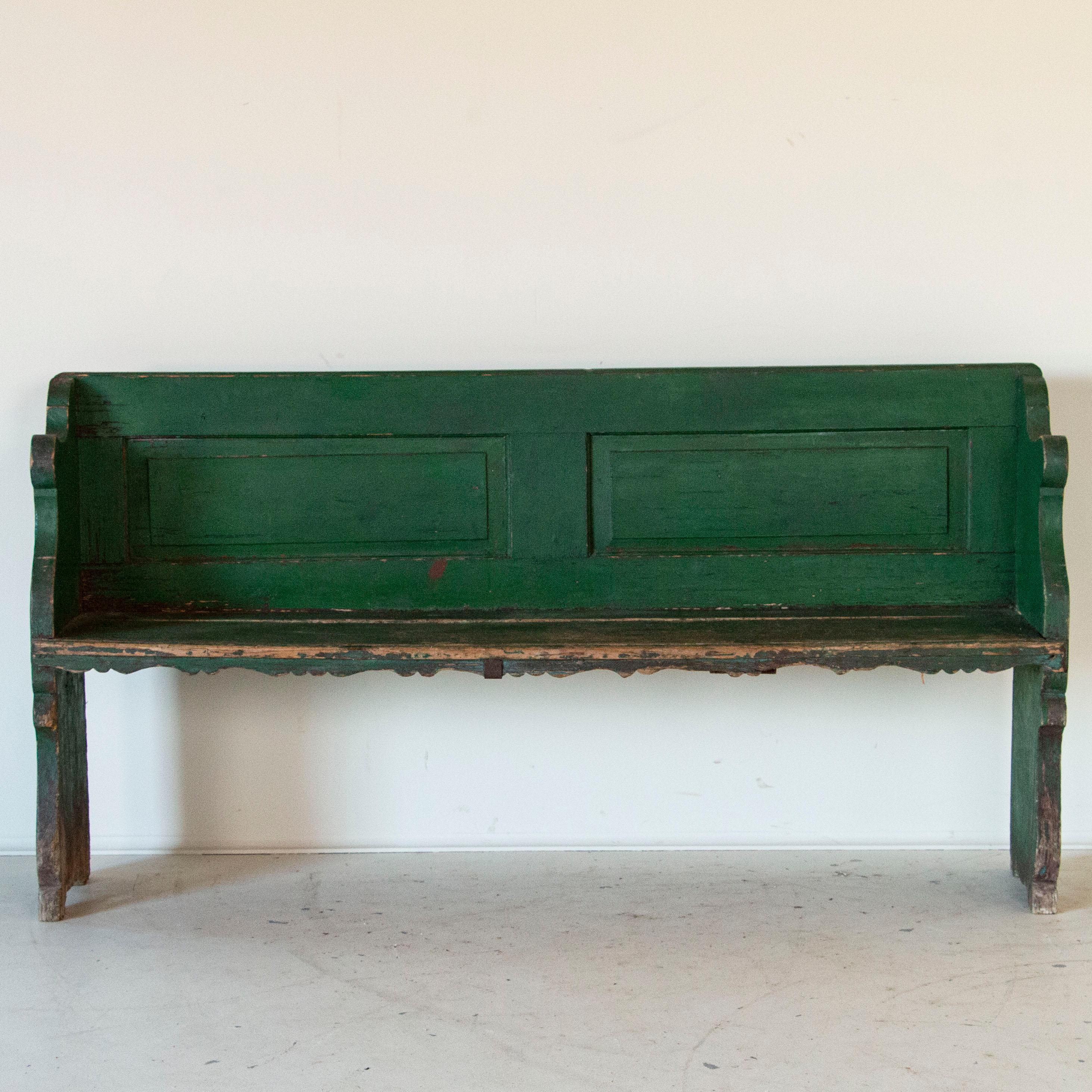 This delightful country bench still maintains its original vibrant green paint reminscent of green rolling hills and spacious pastures. Due to time and use, the green paint on the seat has been worn to the natural pine below, with minor