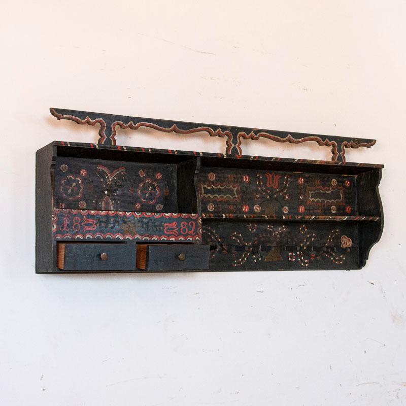 This fun and festive hanging rack is a wonderful example of the Folk Art found throughout Eastern Europe in the 1800s. While the rack appears black to the eye, it is actually a dark shade of blue with black, red and white hand painted accents