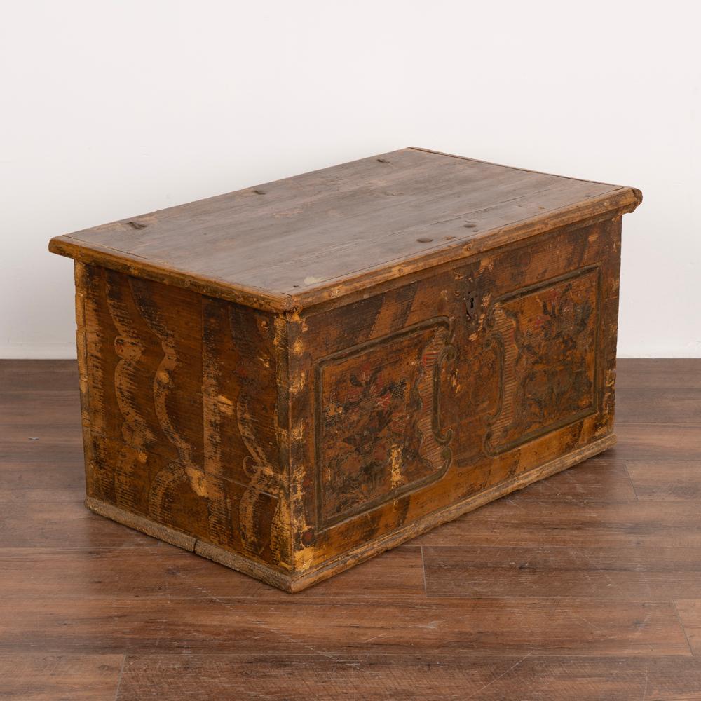 Antique original hand painted and carved trunk dated 1854.
The original painted finish has been worn and distressed through generations of use, with faint red and green remaining on the flowers and traditional brown background.
The interior top