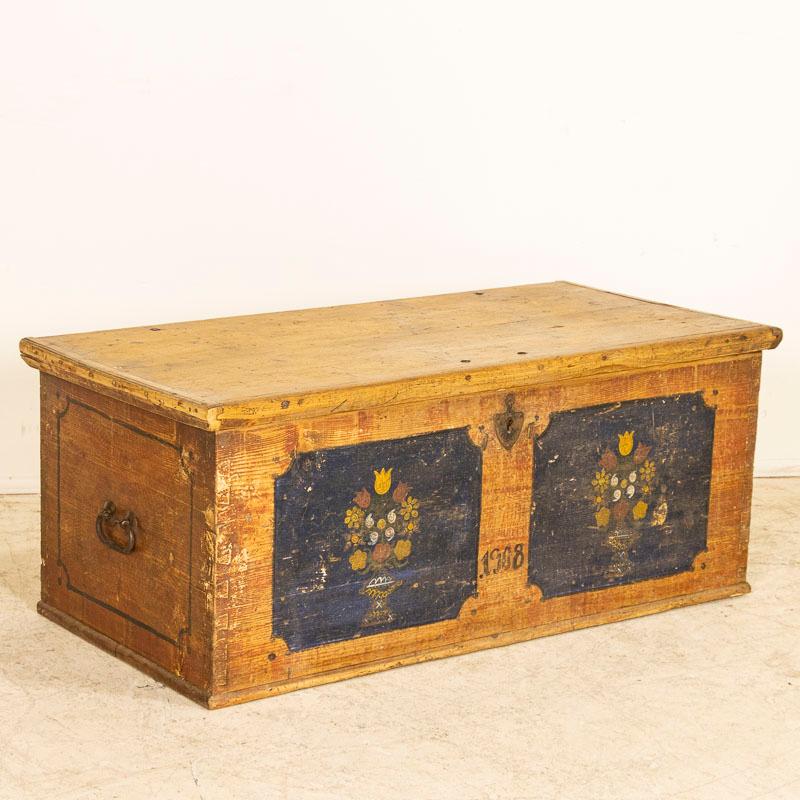 The inviting charm of this trunk comes from the original hand-painted panels of dark blue embellished with delightful vases of bright colorful flowers seen in many Eastern European antiques as flowers were a favored traditional motif.  This flat top