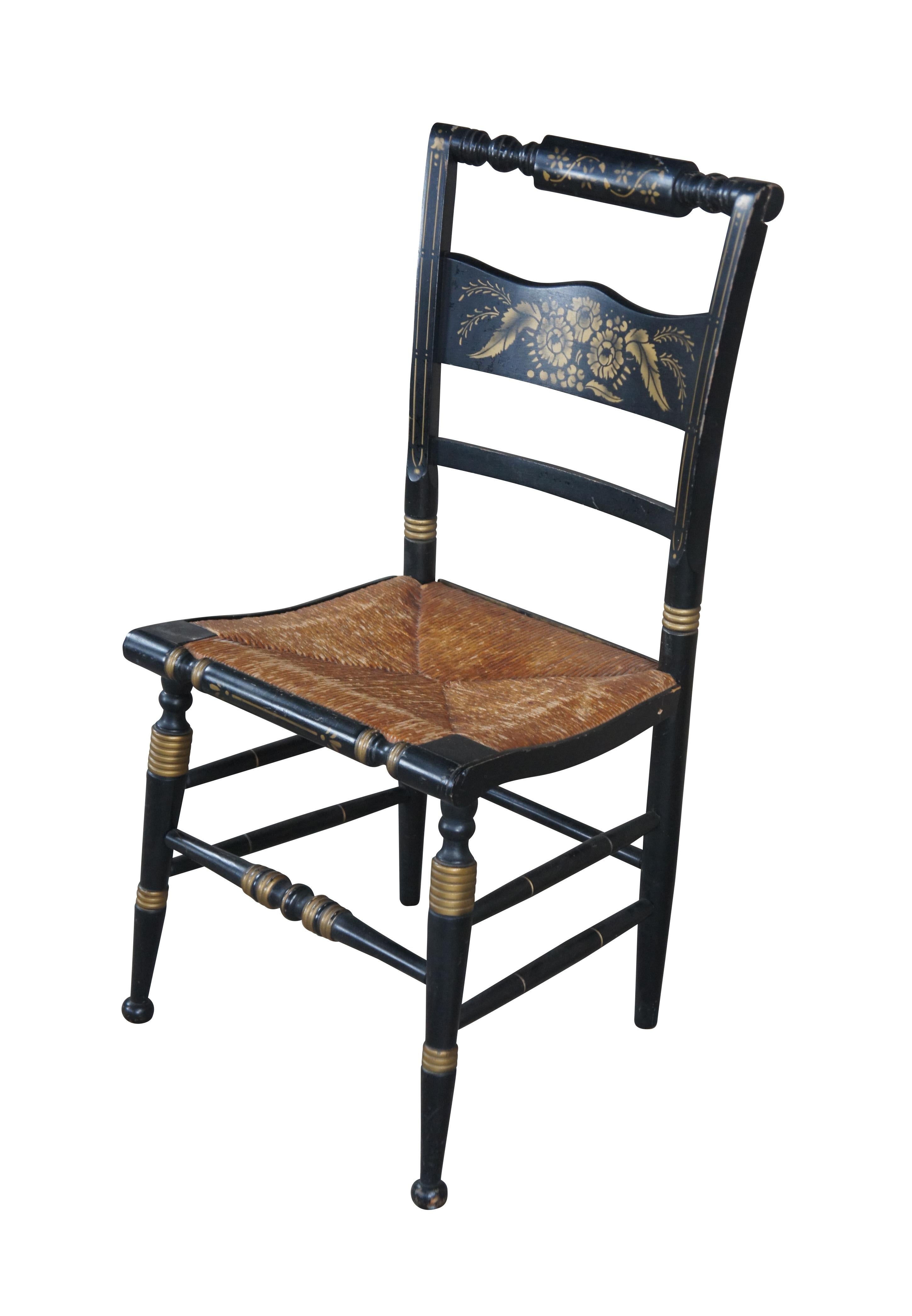 A turn of the 20th century Hitchcock stenciled farmhouse chair. Features a floral berry and leaf / foliate design, ribbed accents and rush seat.

Hitchcock chairs are a true American original. They were designed by one man, intended to be