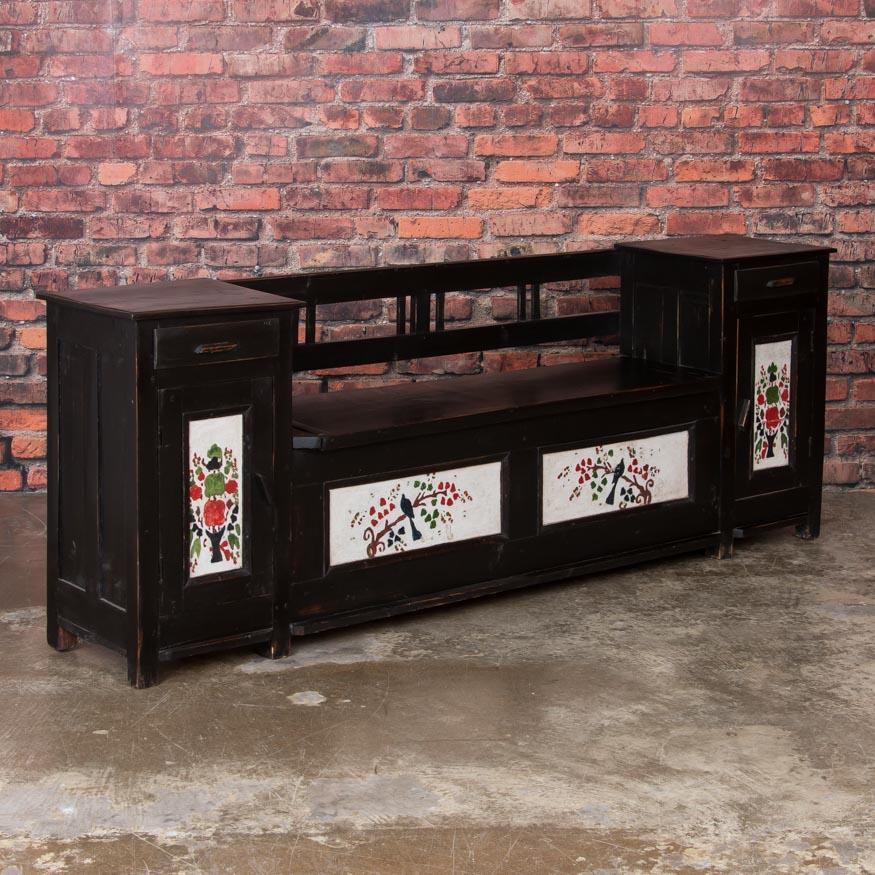 This lovely original painted black bench is a unique find. In addition to the traditional storage beneath the bench seat, there is a small cabinet and drawer that flank each side of the bench. This provides both additional storage and an interesting