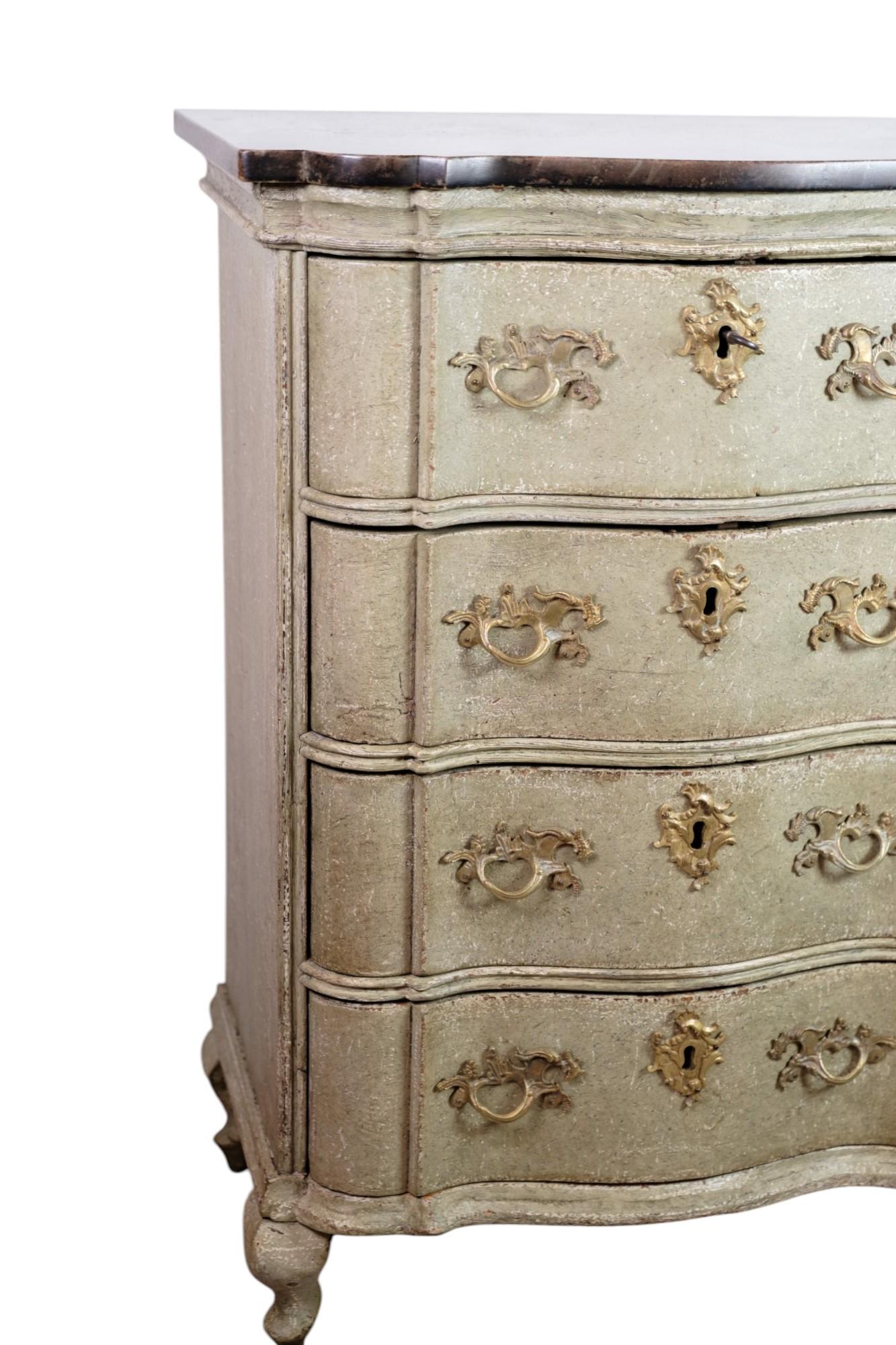 Un'antica cassettiera del 1740 realizzata in stile barocco. La cassettiera ha la sua vernice grigia originale, che ne evidenzia il fascino storico, ed è dotata di un piano in marmo marrone scuro. Le sue caratteristiche forme curve e gli intagli