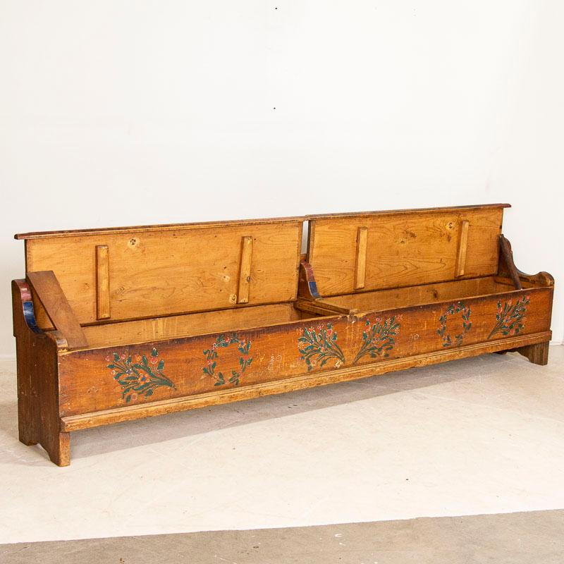 This long 9.5' antique pine bench from Romania still maintains the original folk art paint from 1929 the year it was crafted. The traditional folk art of the late 1800's into 1900's included floral motifs painted along the front and back such as