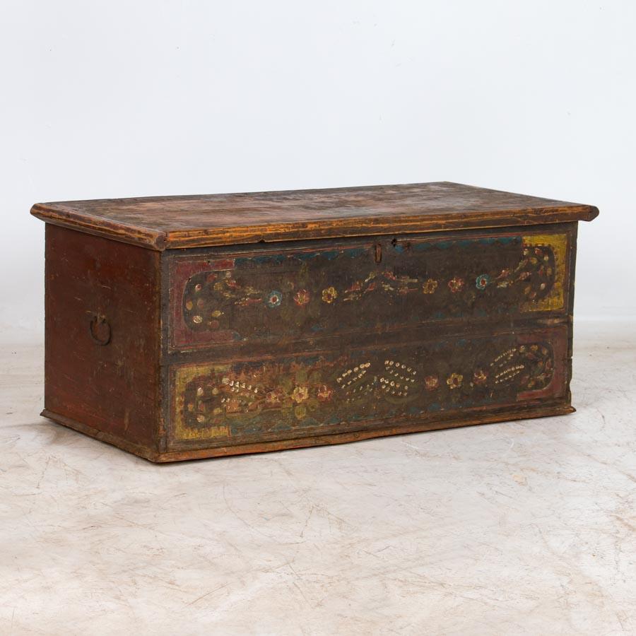 Perfect as a unique coffee table, this original painted trunk with red, yellow and green floral details is a great example of Romanian Folk Art from the mid-1800s. The flat top allows it to serve many functions in a modern home, including a coffee