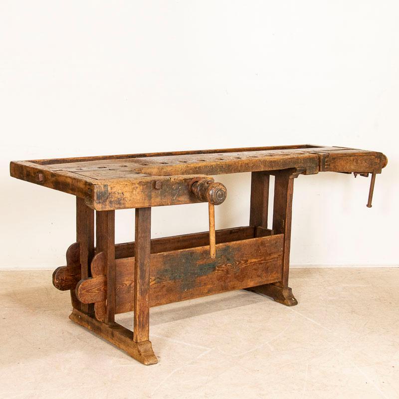 The deep patina of this authentic carpenter's workbench is a reflection of its age and years of use. Every ding, scratch, gouge. paint spill and stain enrich the character and appeal of this old work table. Please examine the close up photos to