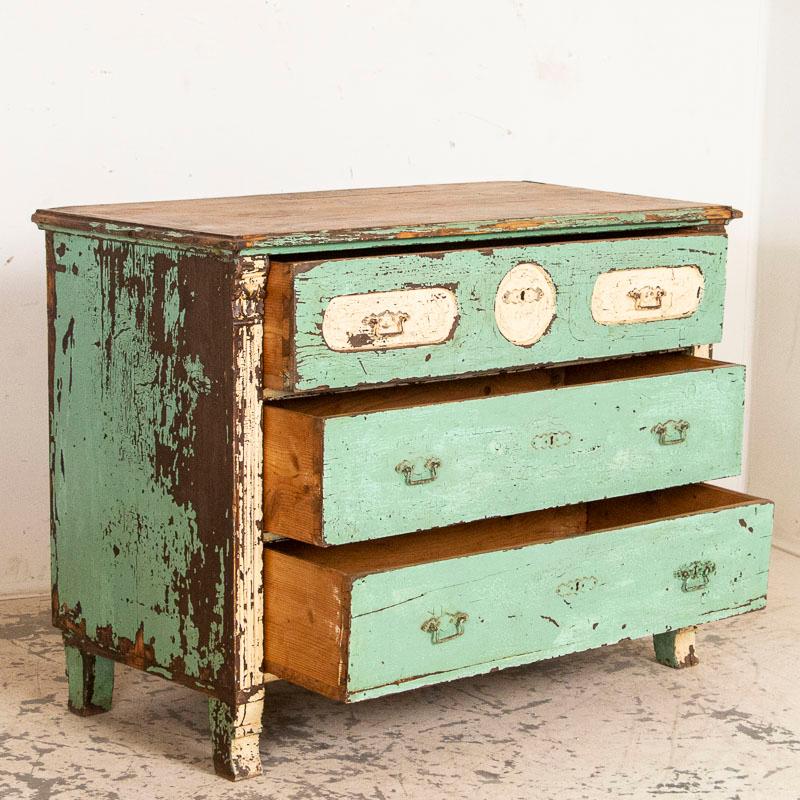 This fun chest of 3 drawers is loaded with charter thanks to the original seafoam blue paint with an aged white painted accent and original old pulls. As you will see in photos, the finish is severely distressed, worn off completely on the top and