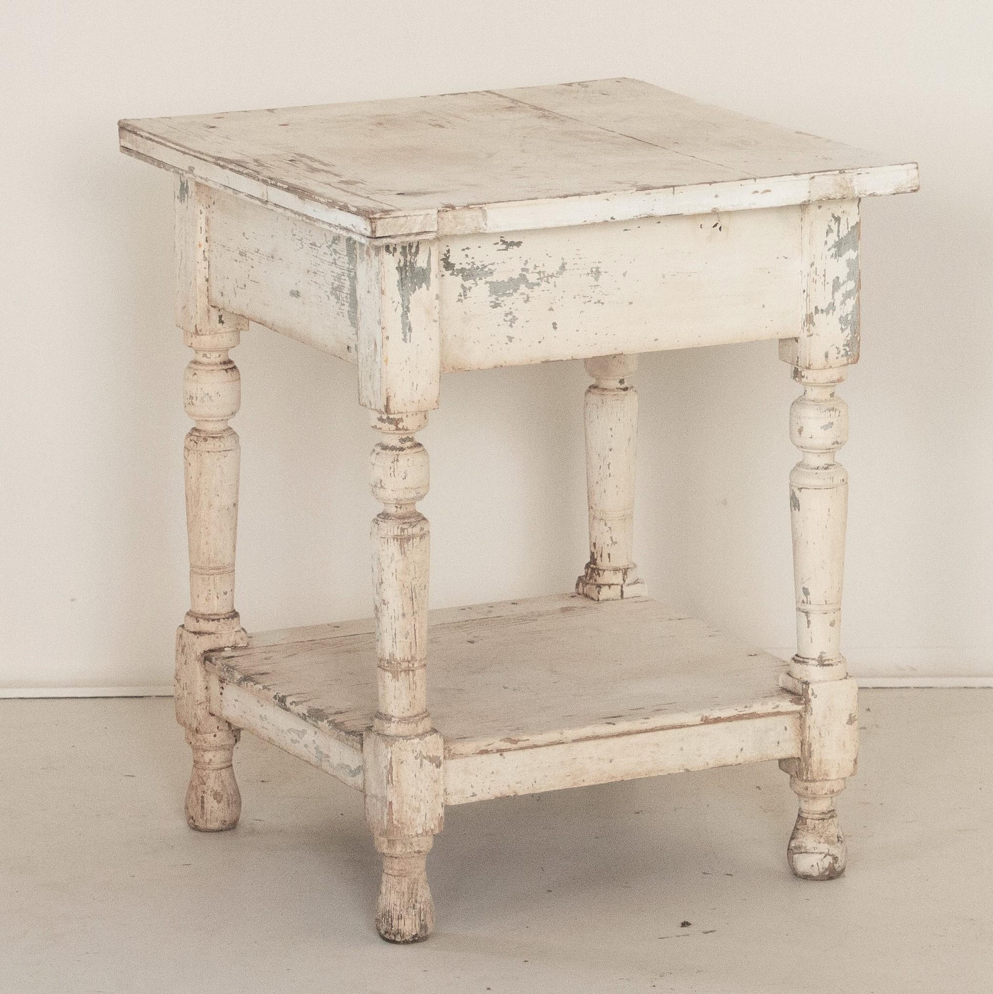 Loaded with charm in a small package, the original white paint is all original on this delightful side table or nightstand. The paint has been naturally distressed and worn over time, adding loads of character to its vintage look. While small, the