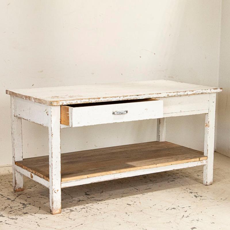 It is the years of use that fill this old work table with character and purpose. The white paint is original, but has been heavily distressed over the many years of use. The lower shelf was left natural pine, creating a nice contrast to the painted