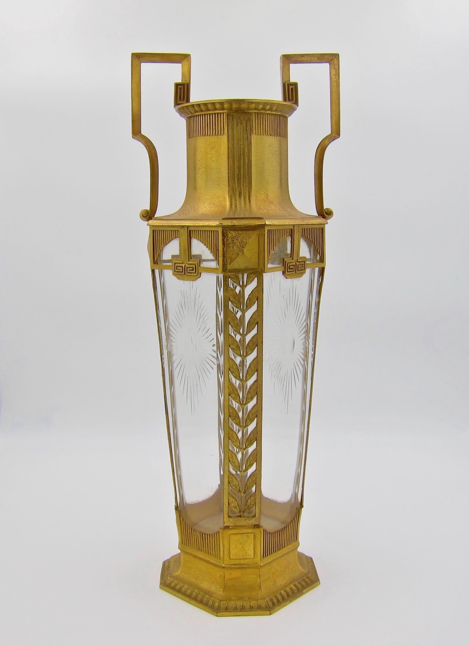 A large antique gilt metal mounted vase with a heavy colorless crystal glass insert. The two-handled vase is an impressive 15.25 in. H and was designed in the Neoclassical style by Orivit-Metallwarenfabrik AOG in Germany circa 1905. 

The outer