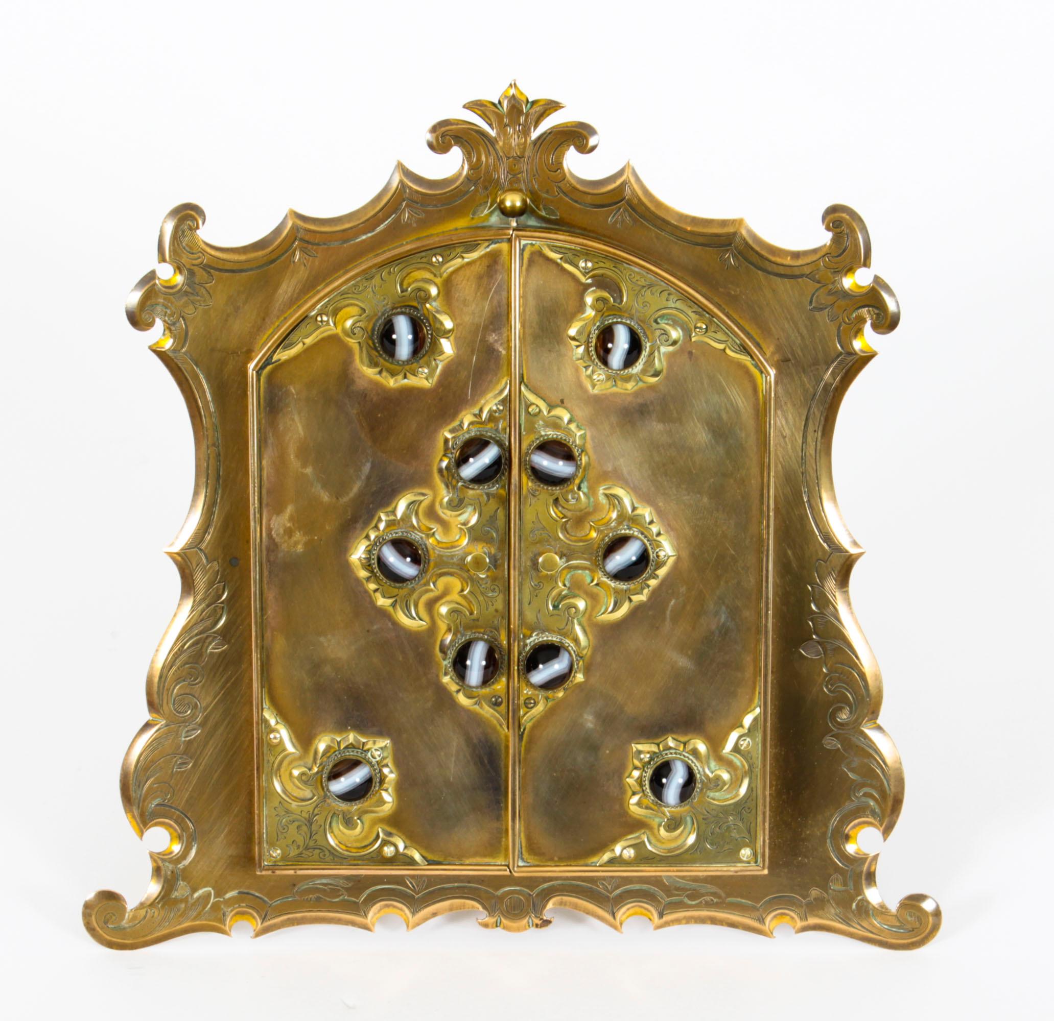 This is a beautiful antique ormolu and agate mounted easel photograph frame, circa 1880 in date.
 
The arched backplate features a wavy edge border having a pair of spring loaded arched doors enclosing five ovals for miniatures or photographs.
