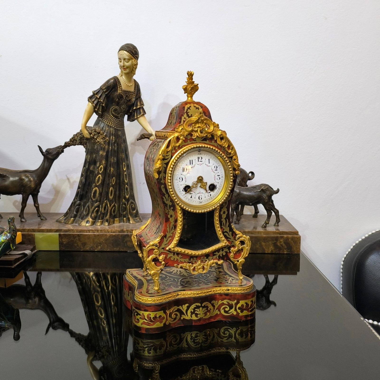 Antique Ormolu French Cartel Clock on its stand, Napoleon III Era.
This is a good-sized French mantel clock dating from around 1880. It has a waisted case with applied brass decoration and brass and tortoiseshell-style inlaid panels. The white