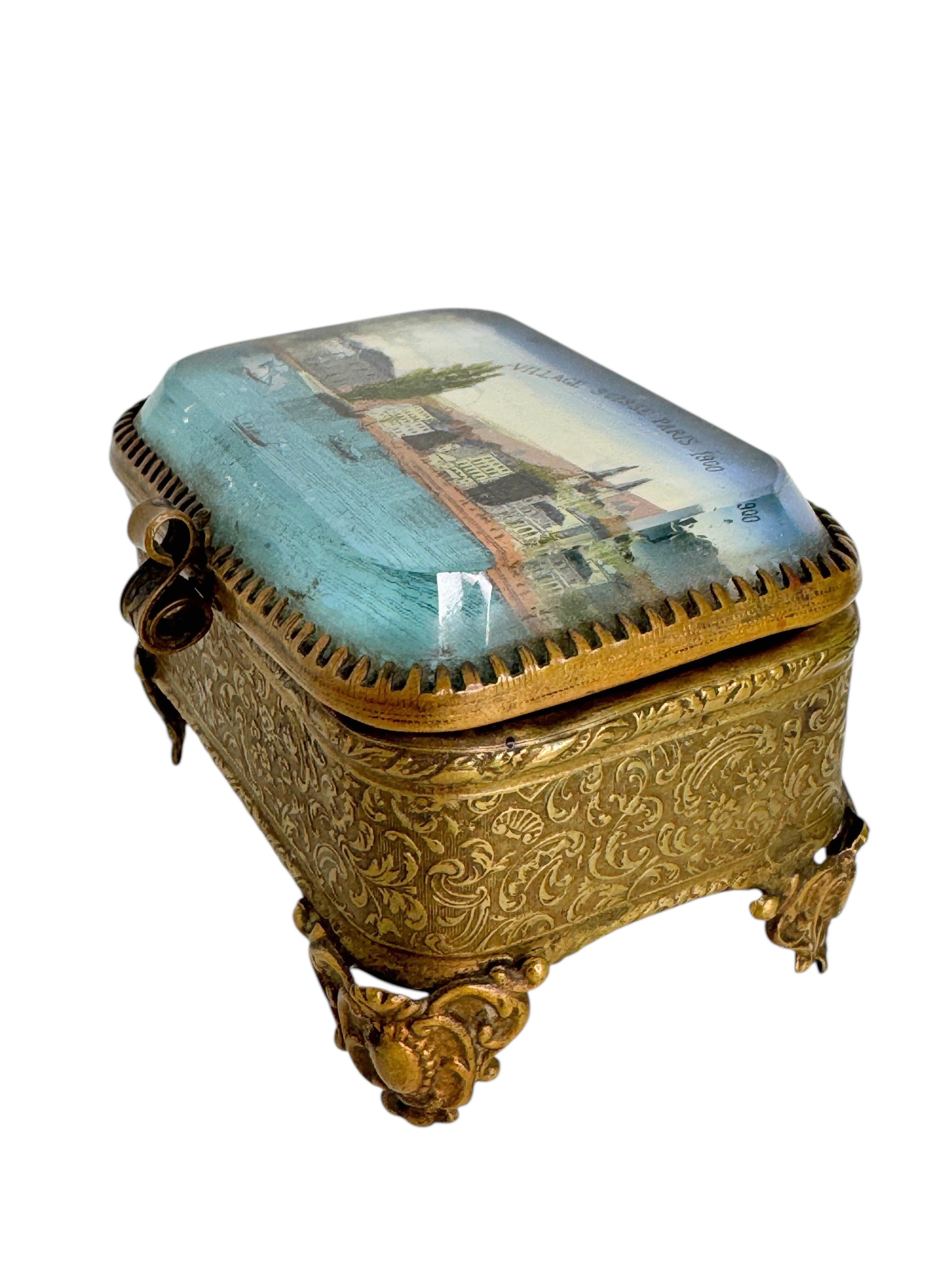 Ancien coffret d'églomisé français - Souvenir de France, circa 1900

Un charmant cercueil français ancien, datant d'environ 1900, avec des ferrures en laiton doré et des panneaux en verre transparent. Le couvercle à charnière présente un verre