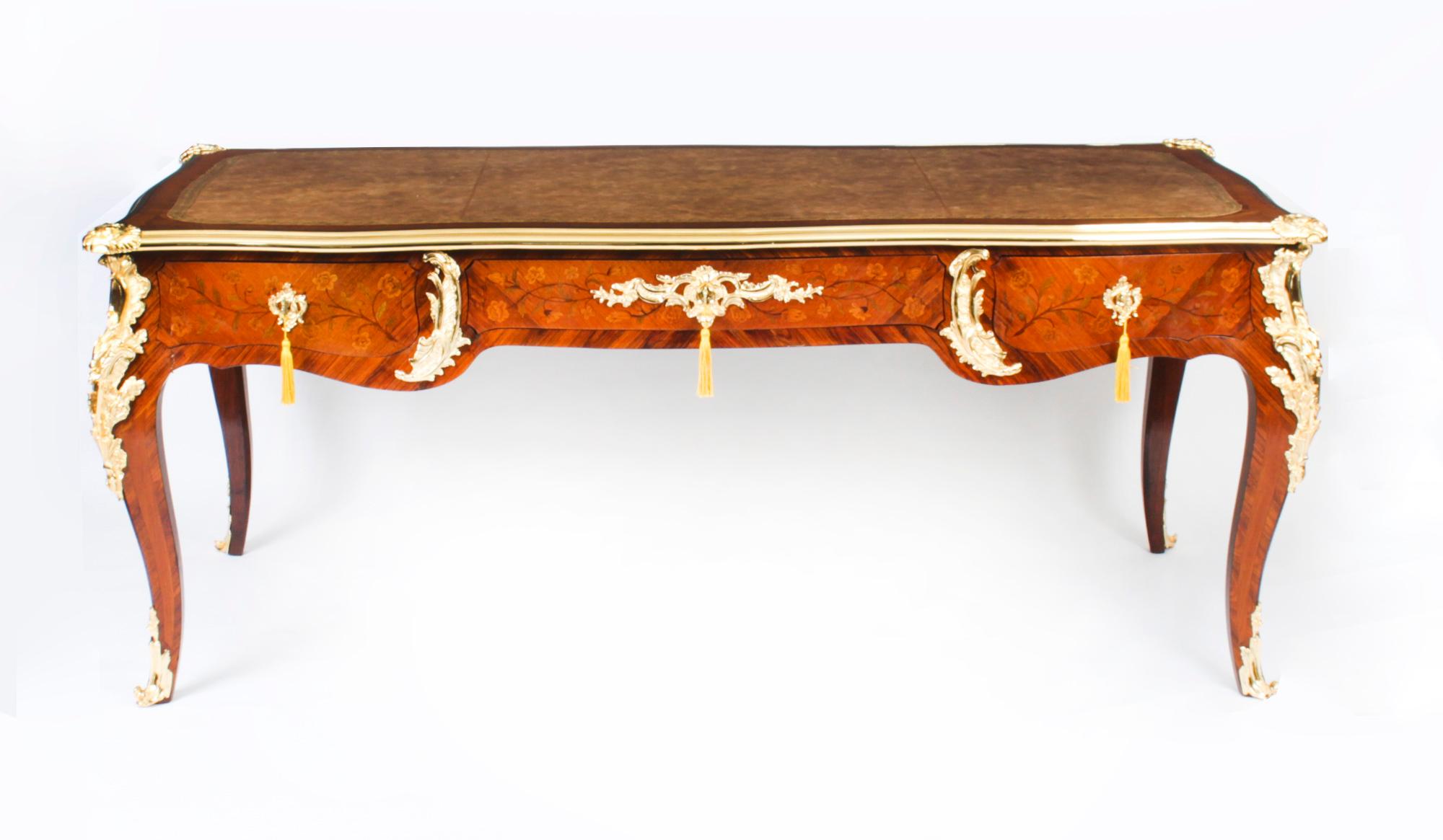 This is a fine and rare antique ormolu mounted French wood and marquetry bureau plat, Circa 1790 in date.

It has highly decorative ormolu mounts that are signed VD on the underside.

The shaped rectangular top has a decorative ormolu border