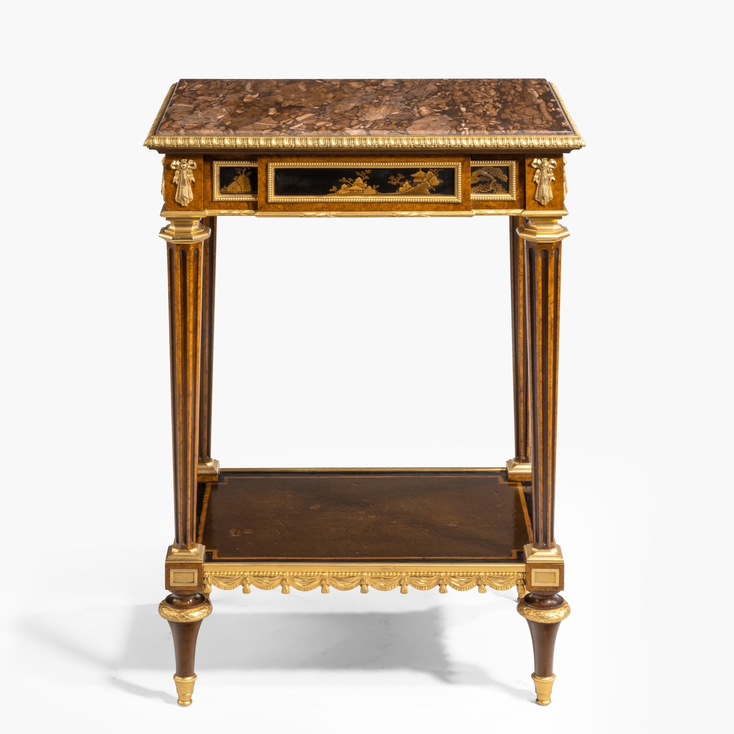 A fine side table in the Louis XVI Manner
By Henry Dasson

Of rectangular form, constructed in amboyna and mahogany dressed with chinoiserie panels, and fine ormolu mounts; rising from ormolu-mounted toupie feet, supporting the lower platform,
