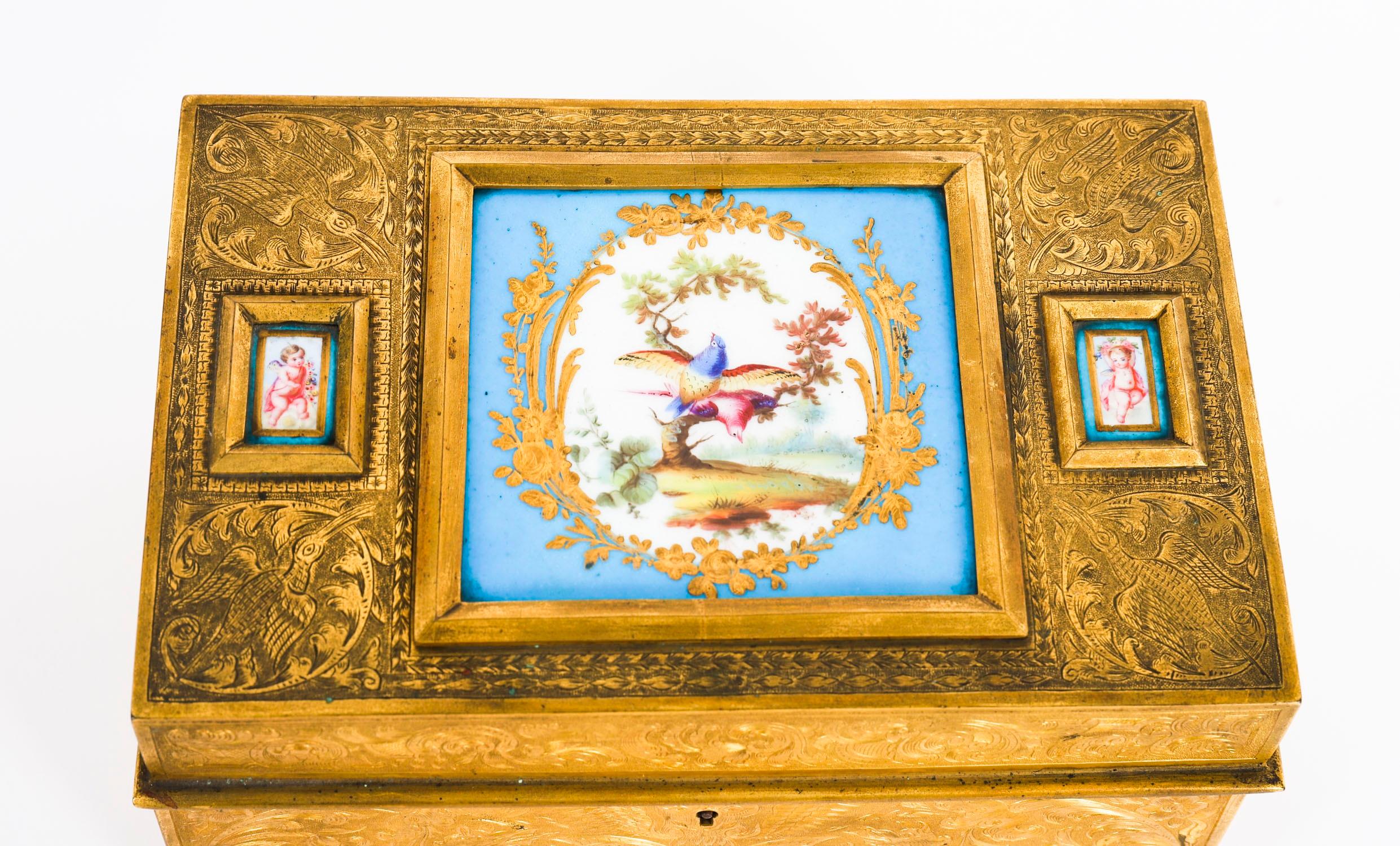 Superbe coffret en bronze doré de Sèvres, ciselé et monté de deux petites plaques émaillées de putti flanquant un grand émail central d'oiseaux dans un arbre, le couvercle à charnière s'ouvrant pour révéler un intérieur tapissé de velours bleu,