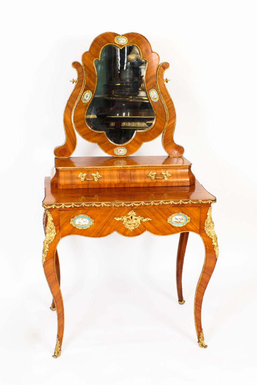 Il s'agit d'une très belle coiffeuse ancienne en bois de Boi, bronze doré et porcelaine de Sèvres datant d'environ 1860.
 
Elle a été fabriquée de main de maître à partir d'un magnifique bois de Violette rehaussé de bandes décoratives en bronze doré