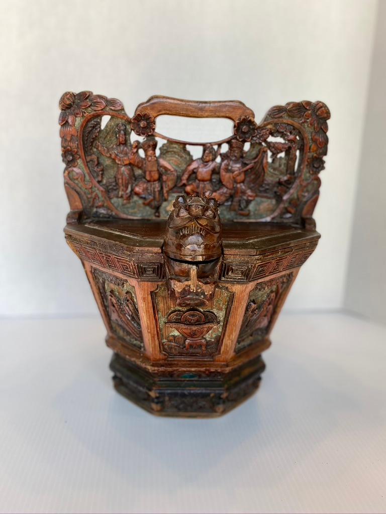 Ornamental Chinese water basket made from hard wood hand carved having. A frog to the opening the mouth opens to pour water. The back opens to put water into it. Other carving surround the bucket.