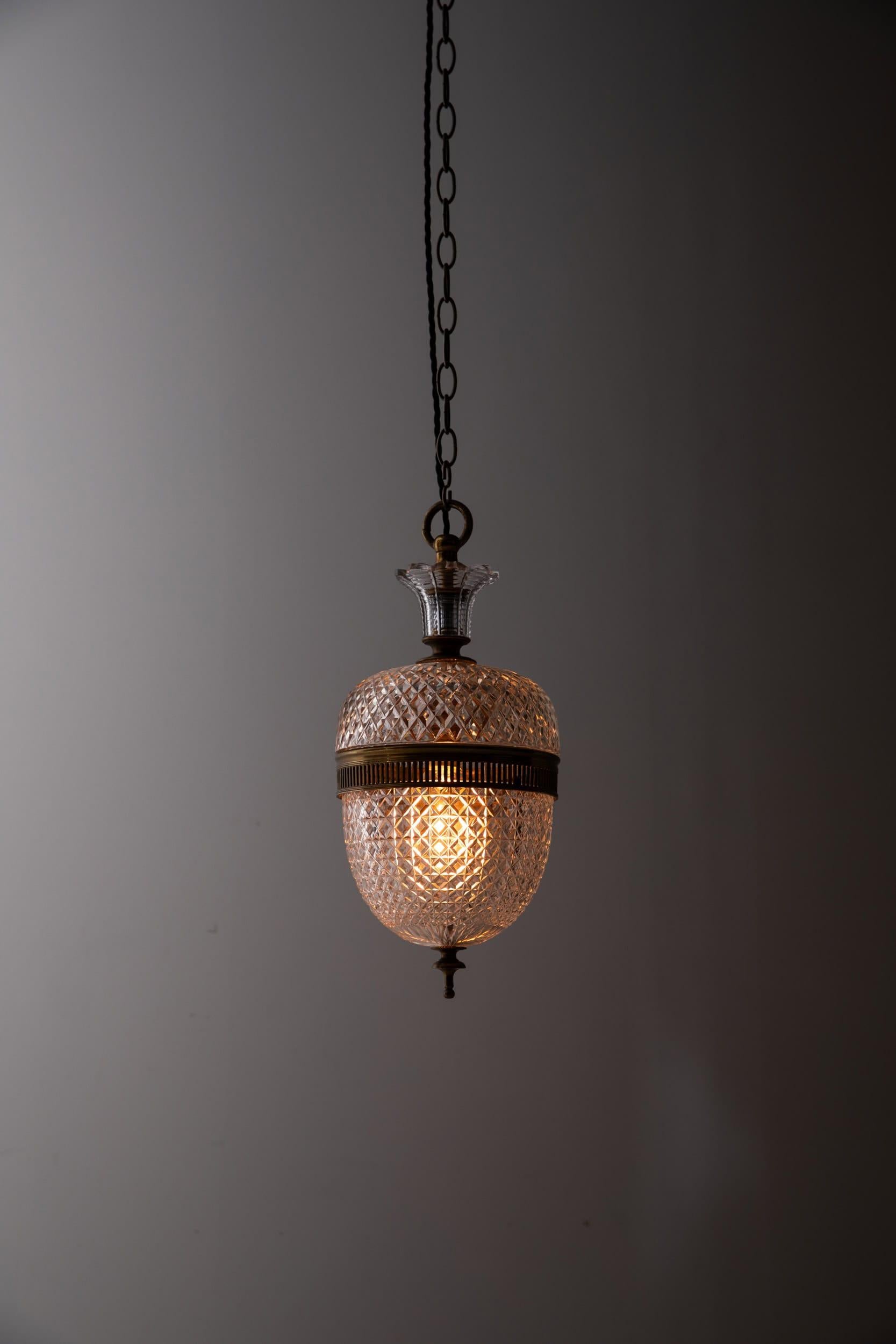 An elegantly formed cut glass pendant light made in Birmingham (England) by F& C Osler. c.1910

Thick hand cut glass shades, with a central pierced gilt brass band and glass covered hanging loop to the top. The lamp brings a touch of historical