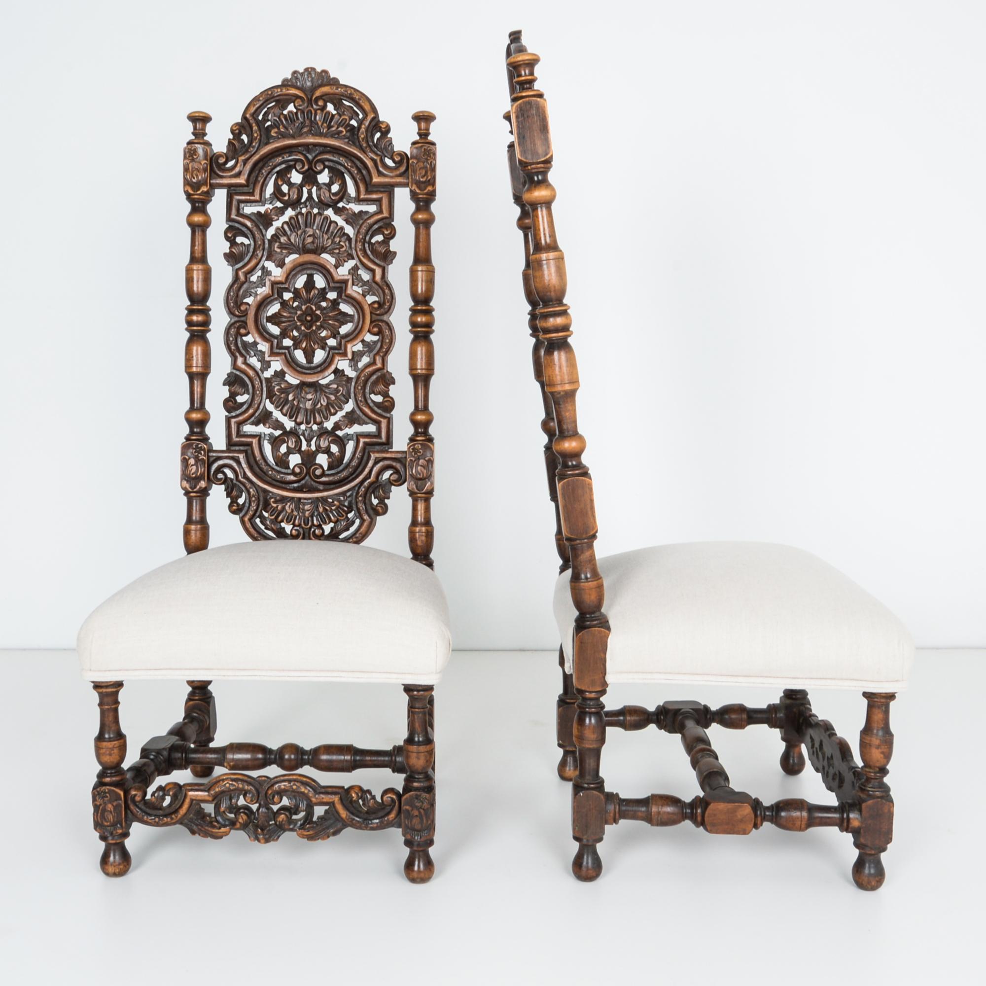 Ornate high-backed upholstered chairs from France, circa 1880. Inspired by the decorative forms of formal French furniture, this chair features elaborate turned and carved supports, with a Louis XVI inspired chair back, and a decorative front