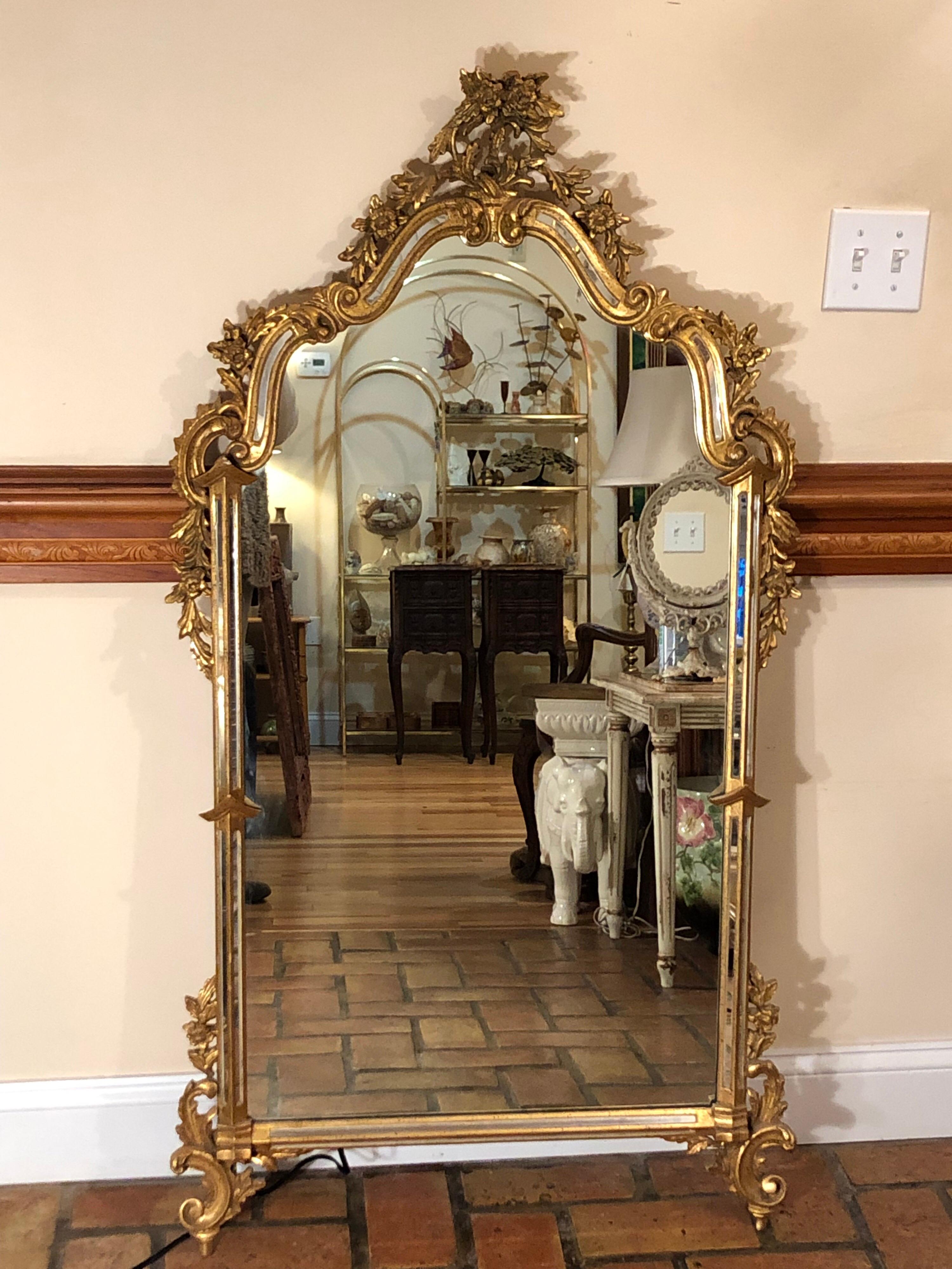 Vintage ornate gilt mirror attributed to Labarge. With mirrored sides and intricately carved detail this mirror would appeal to anyone who loves the Baroque or Rococo styles. Gold gilt finish has tiny specks of black in it.
Perfect for an entryway,