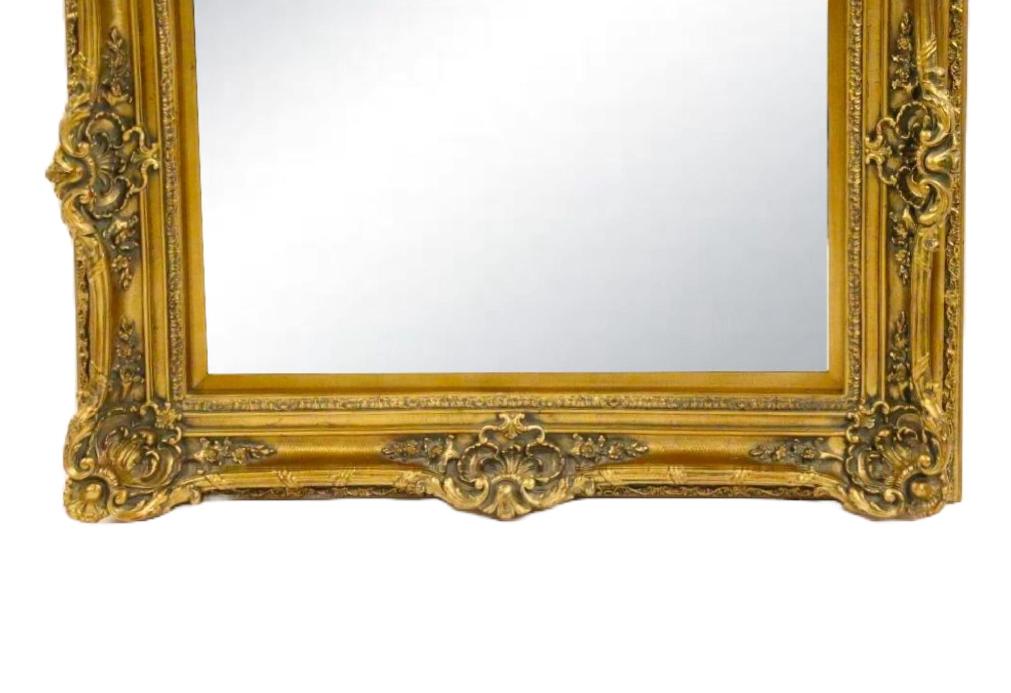 Elevate your home decor with this exquisite antique hand-carved giltwood framed wall mirror. The frame showcases a heavily decorated floral design, expertly crafted to create a stunning visual impact.
This large, Italian-quality mirror features a