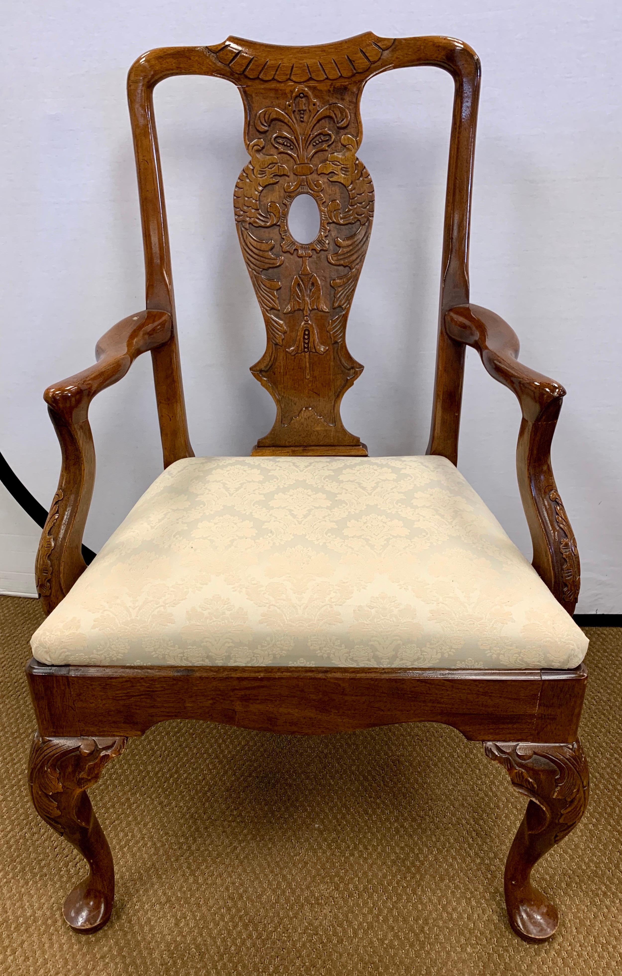 Elegant matching set of eight carved mahogany dining chairs with the most beautiful carved backrests. They were made in NY in the 1940s by Fancher. The seats are a neutral fabric and in good condition. There are eight chairs in all, six side chairs
