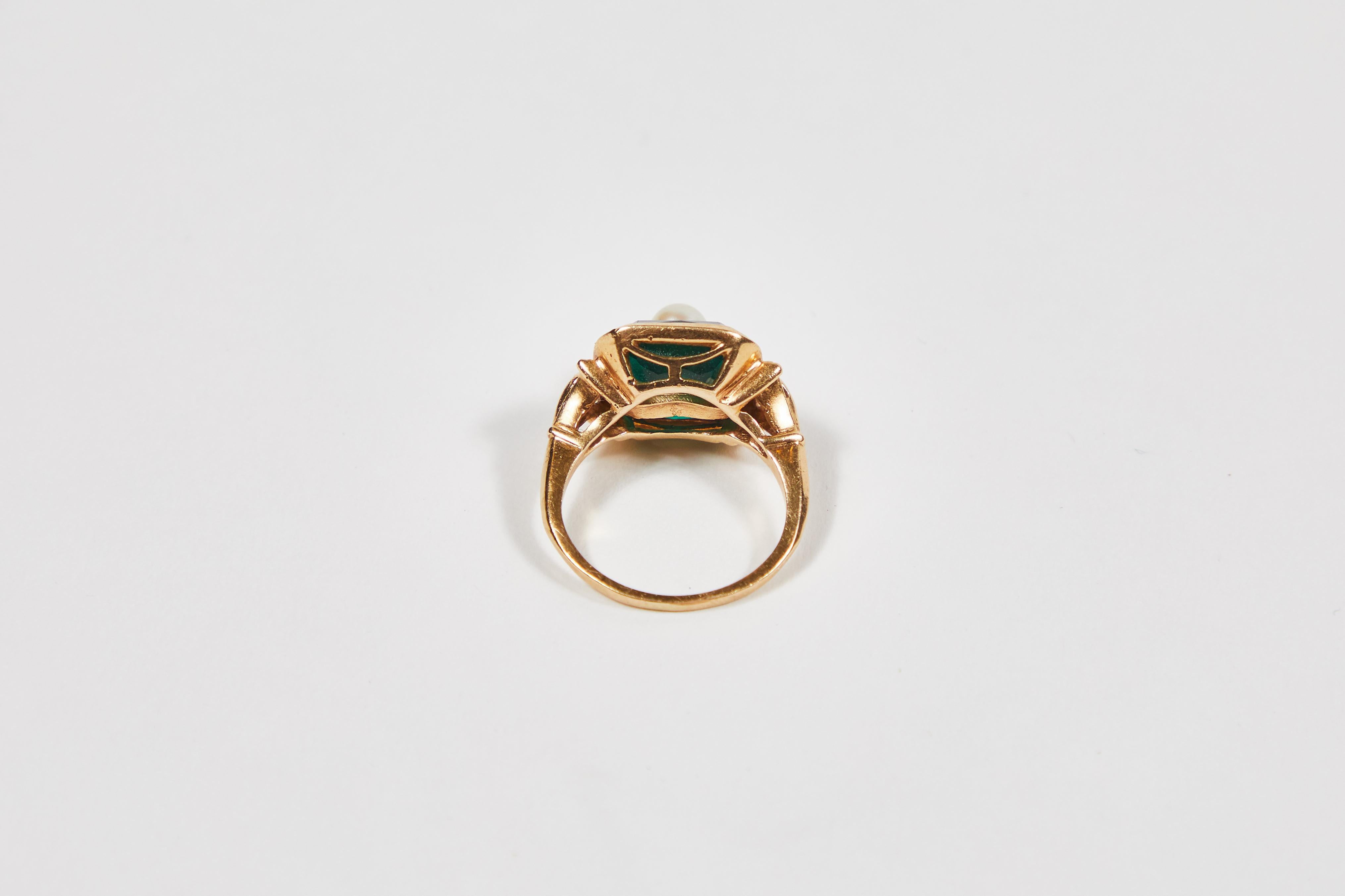 Antique Ostby & Barton 14K Gold Cocktail Ring with Dark Green Emerald Cut Glass Stone with Center Cultured Pearl Accent.

Otsy & Barton were a famed jewelry company formed in the mid 19th Century and came to become to be known as the largest ring