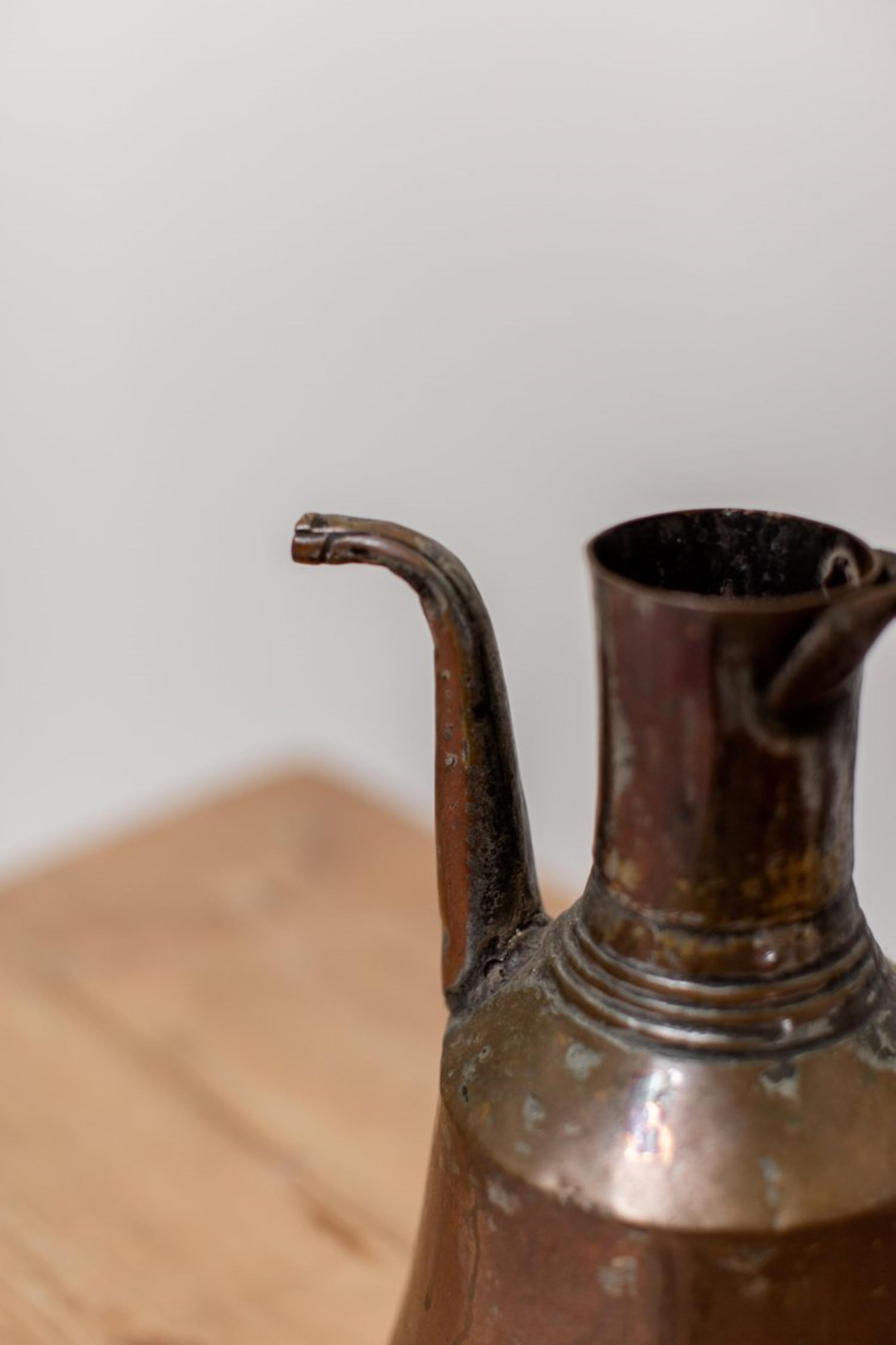 This unique ibrik dates back to the late 19th century (about 1890) and showcases the exceptional artistry of Turkish metalworkers of that time. Crafted entirely from copper, this antique pitcher is in very good condition for its age and boasts a