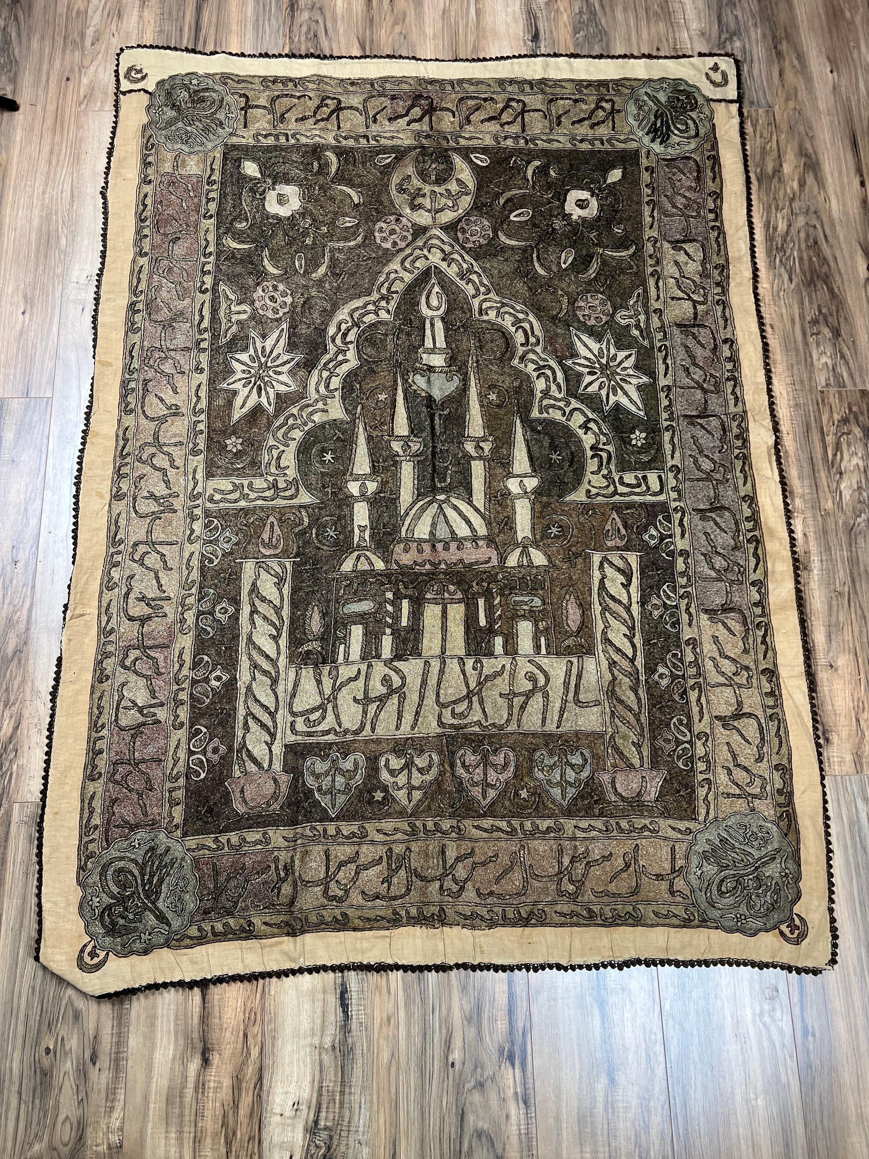 Dieser bemerkenswerte gestickte Wandbehang aus dem späten 19. Jahrhundert zeigt eine große Moschee, die mit komplizierten Metallfäden verziert ist und wahrscheinlich aus dem osmanischen Anatolien stammt. Der zentrale, mihrabähnliche Bogen, der zur