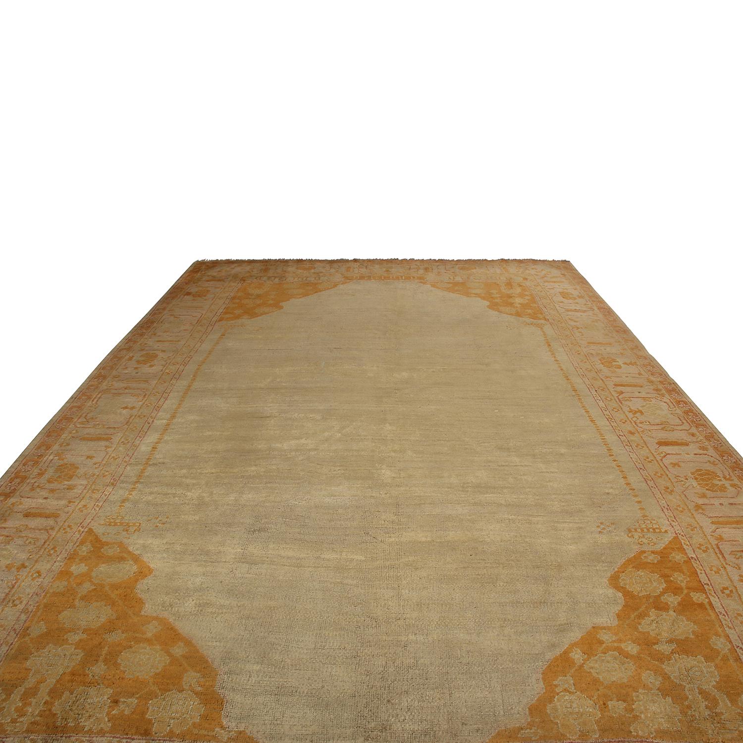 Hand knotted in Turkey originating between 1870-1880, this antique Oushak rug enjoys a subtle, luminous sheen to its quality wool body, accenting the rich autumnal gold, beige and burgundy colorways further complementing the very soothing