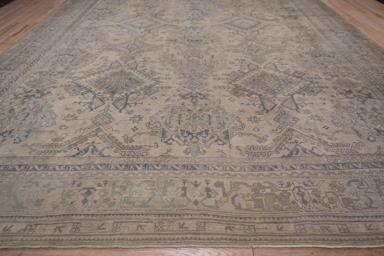 Instead of the usual Turkey red field, this palmette and Yaprak columnar design west Turkish carpet shows a beige field with three full and two fractional uprights. Small stars and other geometric ornaments are scattered about, giving busier