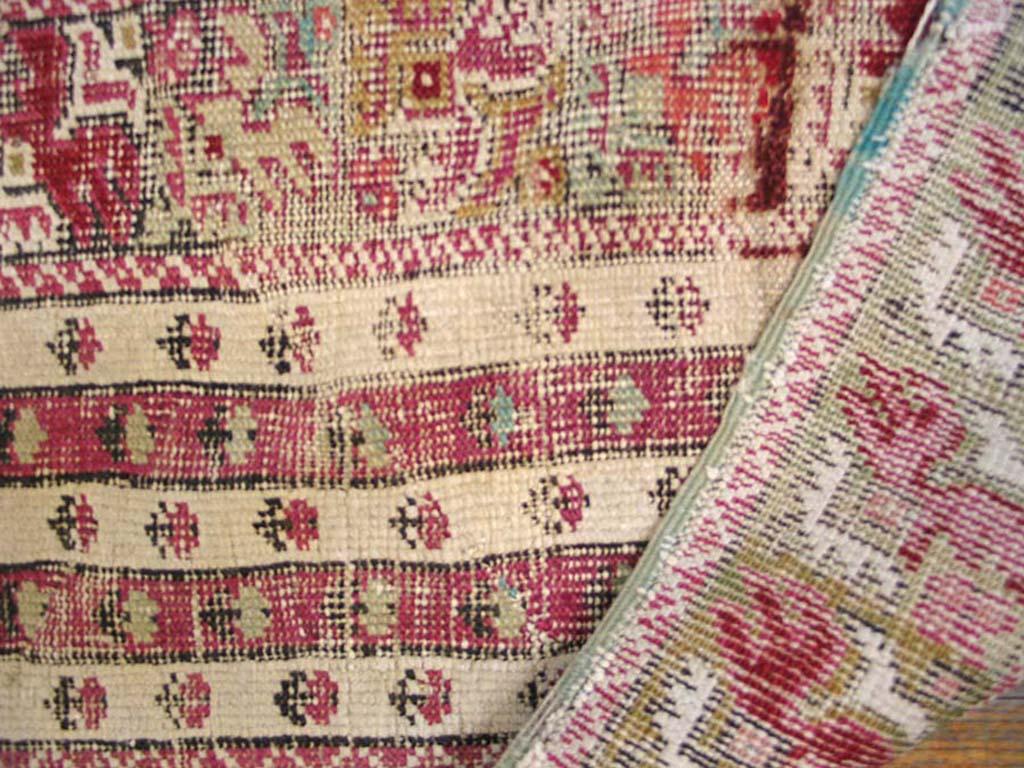 Ghiordes, slightly to the east of Oushak in western Turkey, is famed for antique prayer format rugs. This somewhat worn, but still characterful carpet from circa 1820 has an open light green field with borders and other derails in crisp white