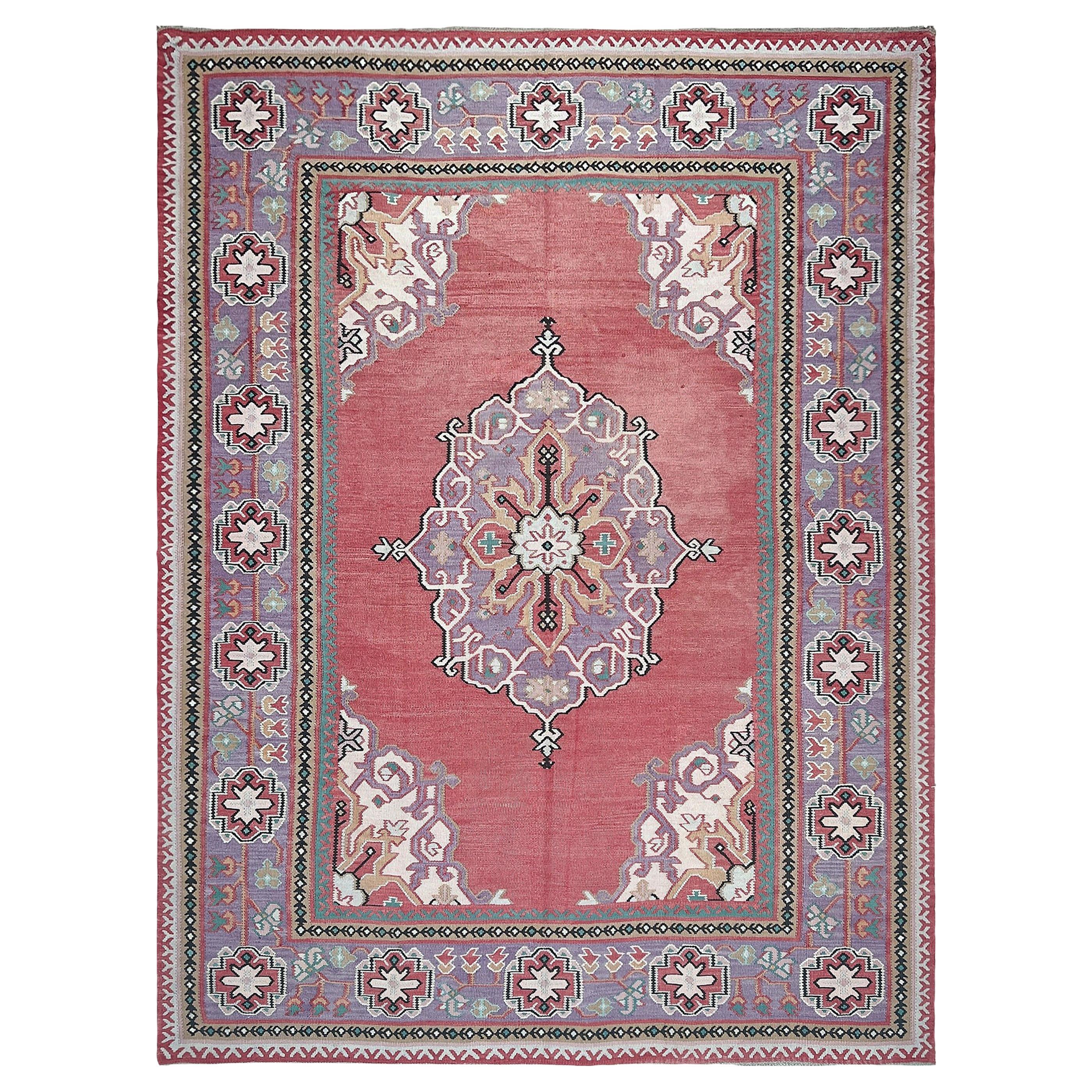 Ce kilim antique d'Oushak, datant des années 1930, illustre le côté poétique du tissage anatolien, où la géométrie, la couleur et le folklore se fondent dans une harmonie tranquille. Rare survivant d'une tradition de tissage abandonnée, il présente