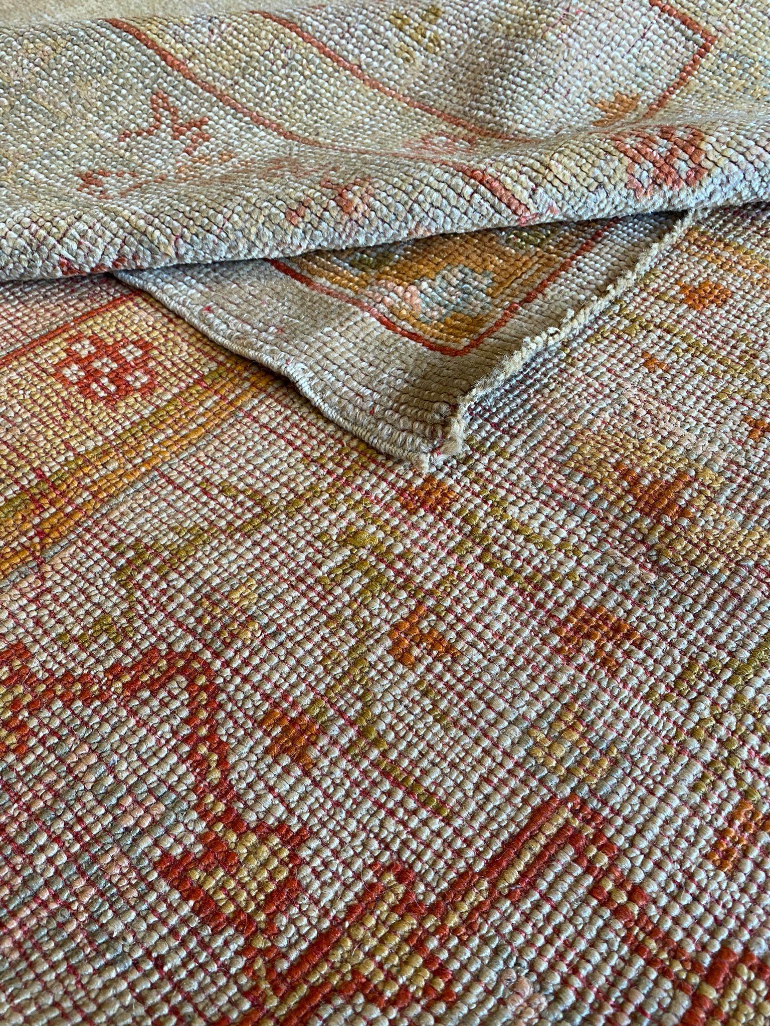 Der antike Oushak-Teppich ist ein atemberaubendes Kunstwerk, das zeitlose Schönheit und Raffinesse ausstrahlt. Seine Faszination liegt in der unglaublich sanften Farbpalette, in der beruhigende Blautöne die Hauptrolle spielen, die durch subtile