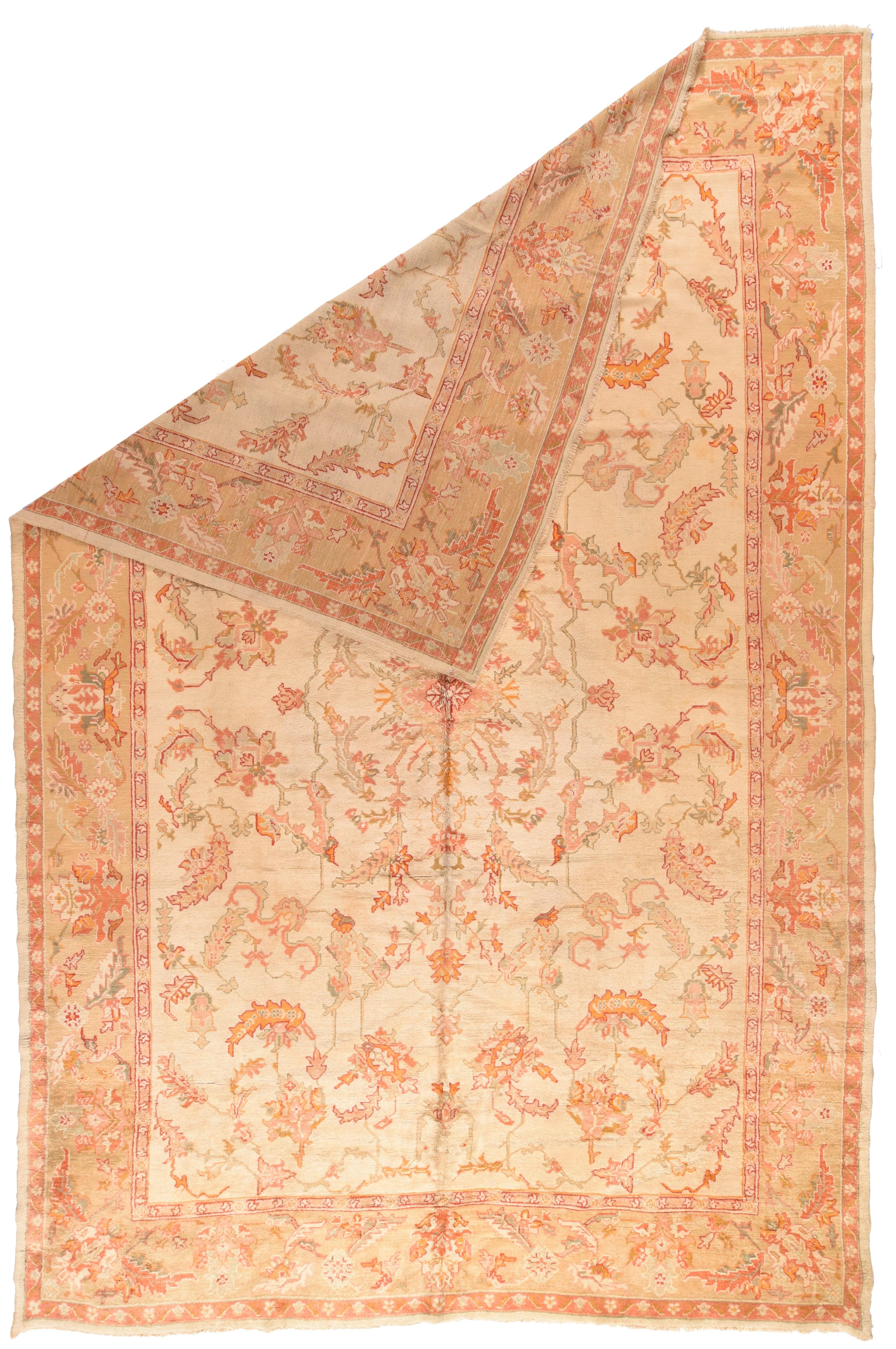 Antique Oushak Rug 9'5'' x 15'9''. The sandy straw field features a four-way layout of cloud bands, barbed lancet leaves, curving vinery and angled palmettes, all around a small, rayed central medallion. Buff border with two palmette types. Accents