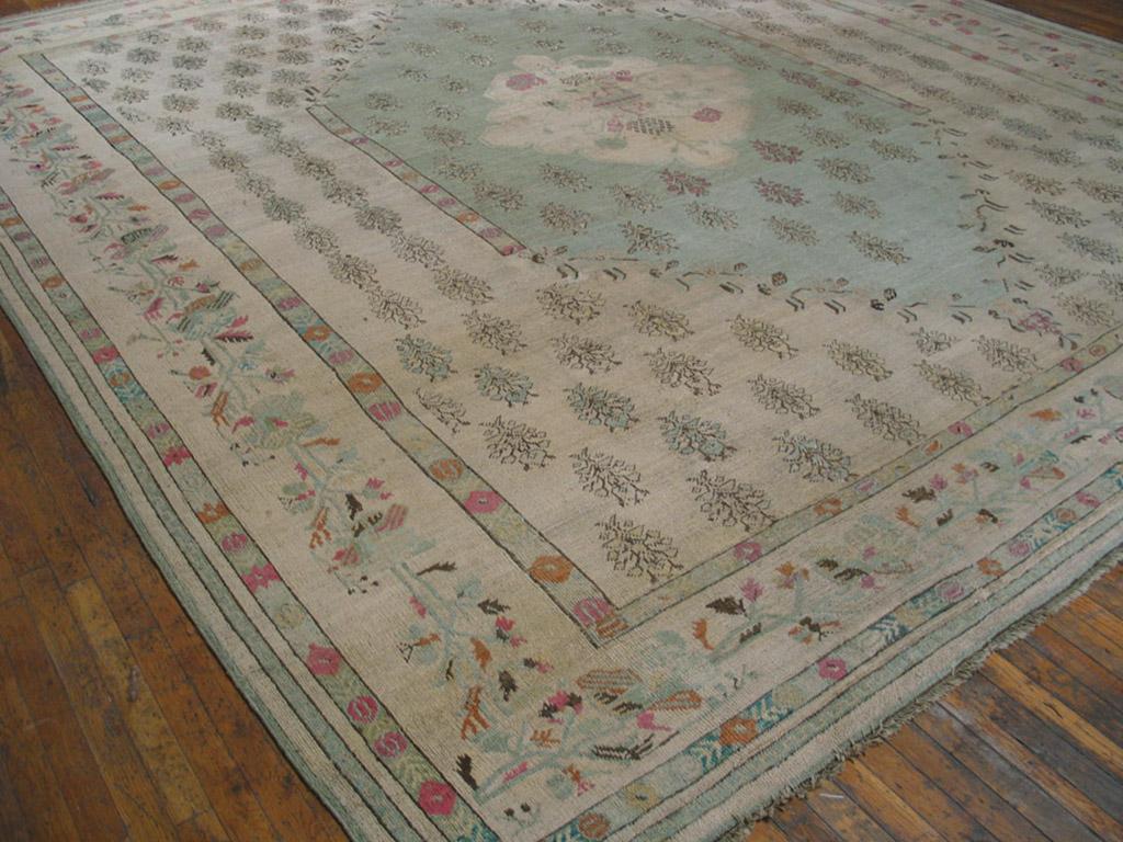 Ivory field, ivory border, generally very light tonality without being pastel make this squarish antique Oushak carpet special. The fieldhaslf-drop array of tiny, leafy flowers continues into the medallion. The broad border gives the flower and leaf