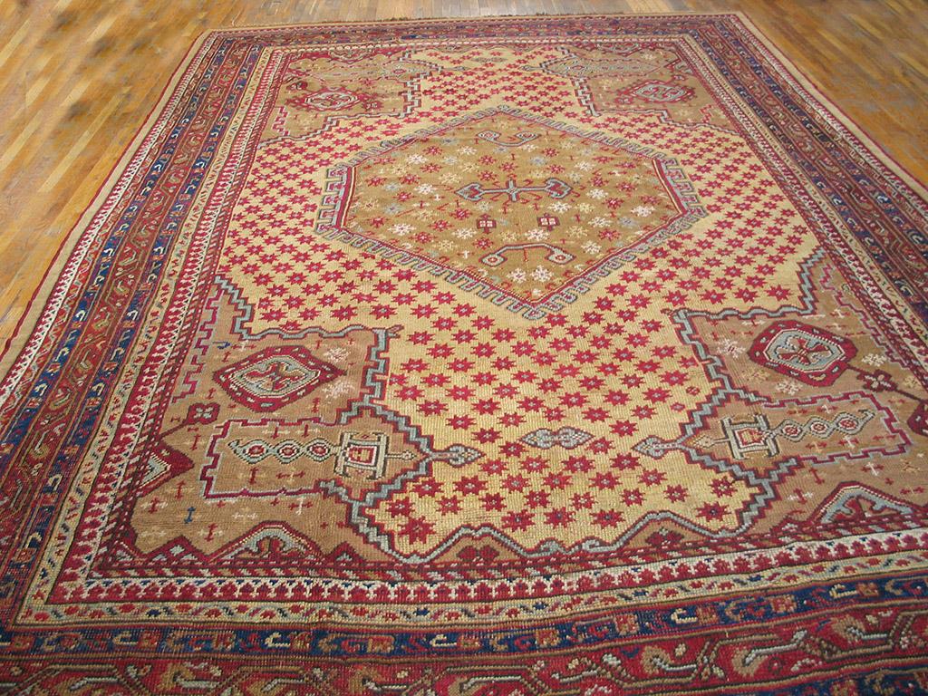 This pale yellow medallion carpet is a direct descendant of classical Ottoman Oushaks with a hexagonal star-filled central panel and pointed stepped corners . Red stars are uniformly strewn all over the field. Eight patterned borders, including a