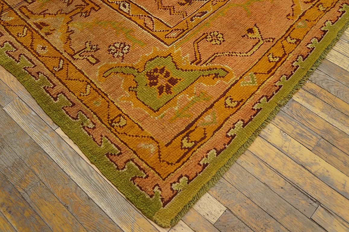 A light lime green open field is centred by a pale salmon medallion and is clasped by en suite quarter corners. The edges of these elements are roughly and irregularly drawn as if the weavers were following their own inclinations. The main border is