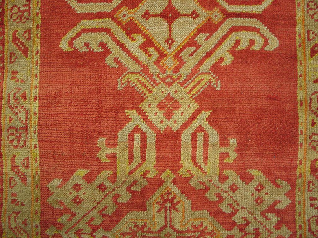 The clear red field of this circa 1900 Oushak runner displays a column of five complete and two fractional lozenge and cruciform based devices as seen on 19460. There are no other ornaments to take away from the bold pattern. As with Oushaks