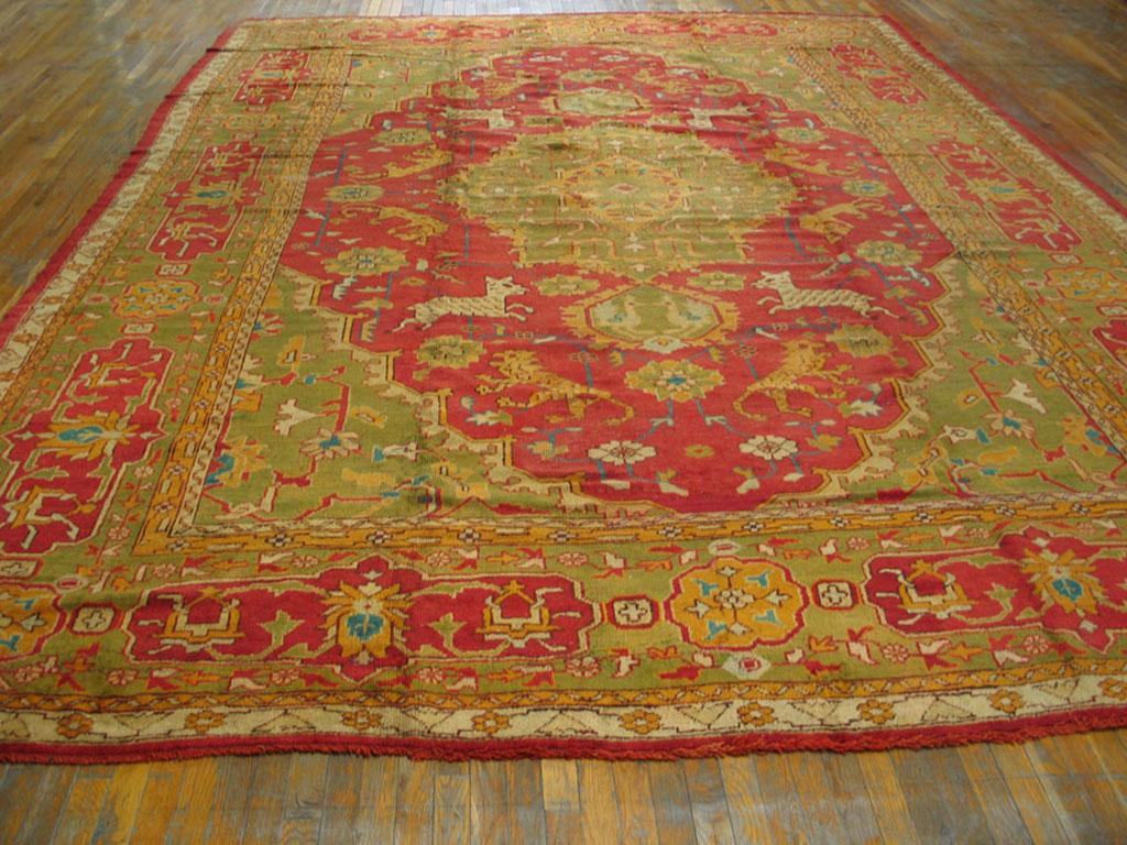 Very few west Turkish Oushak carpets employ animal depictions as important design elements. This exceptional circa 1900 carpet is drawn in the Heriz style with running leopards and zebras around a cloud-band filled, pendanted medallion, on a red