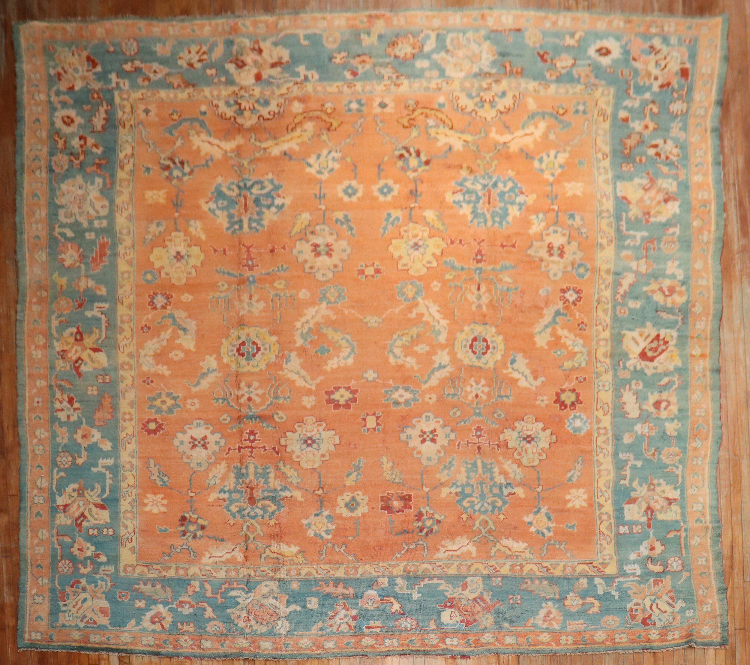 Ein antiker Oushak-Teppich aus dem frühen 20. Jahrhundert mit einem kürbisorangenen Feld und einer blaugrünen Bordüre

Maße: 12'10