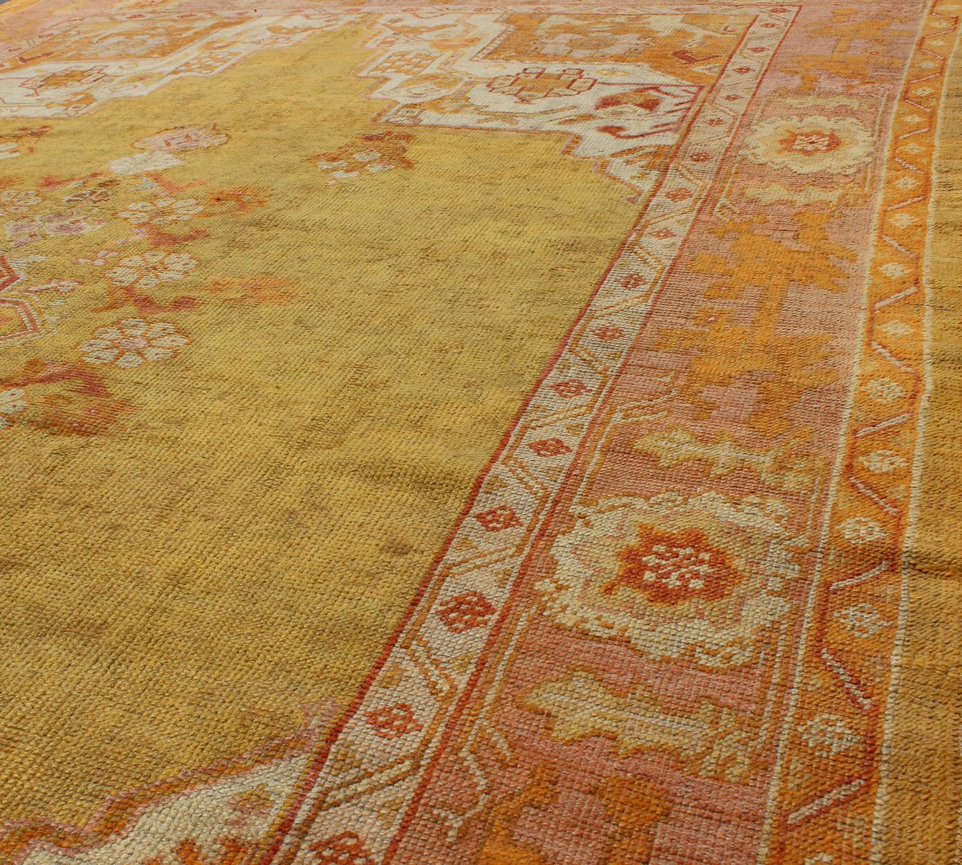 20th Century Antique Oushak Rug in Yellow Green Background, Pink Border, Red & Orange Accents For Sale