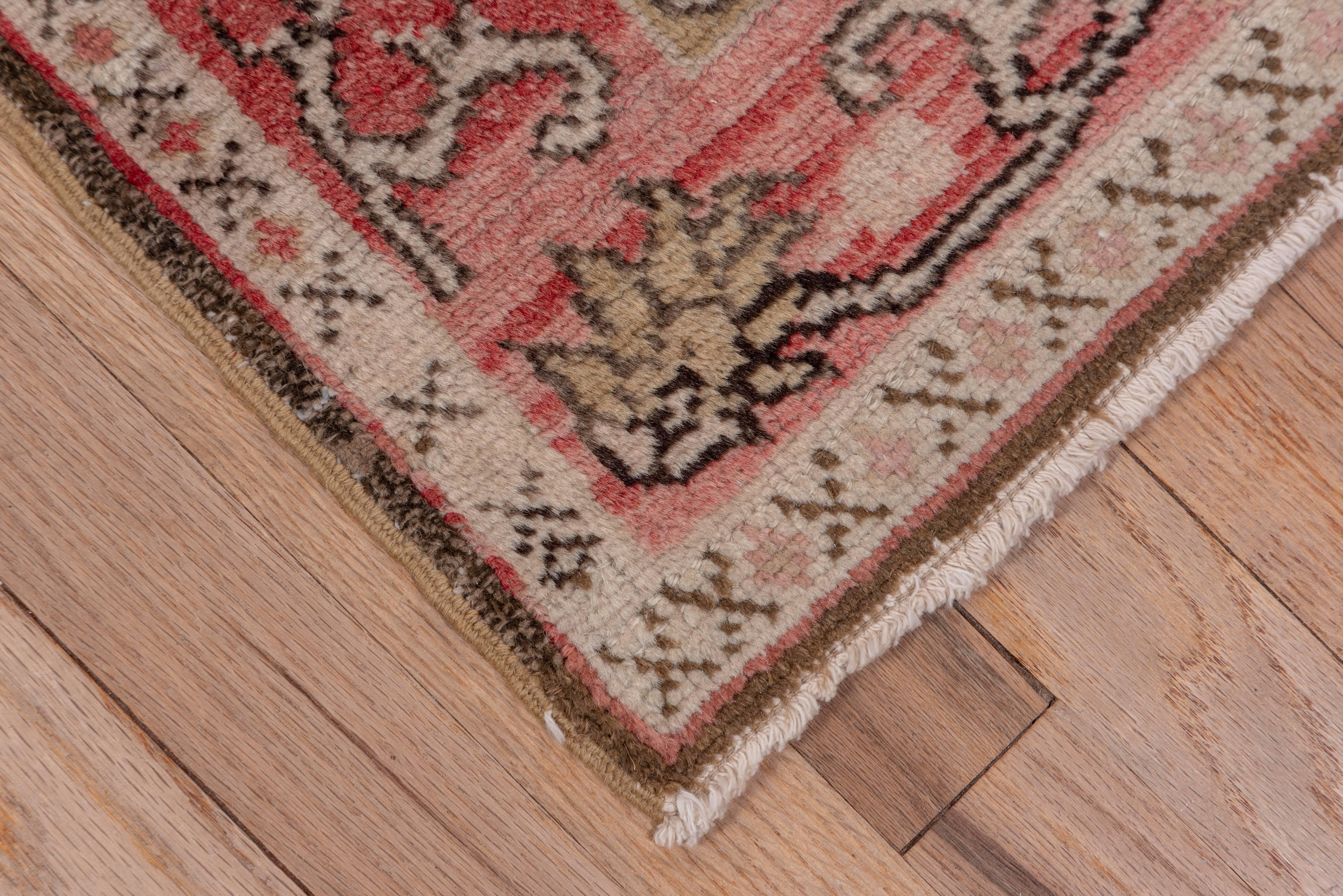 This western Anatolian workshop runner has a Caucasian Shirvan design of five stepped hexagonal disjoint medallions detailed in ivory, beige, red and dark brown on a sandy field, set within a red border with a scrolling tendril ornament. The rug