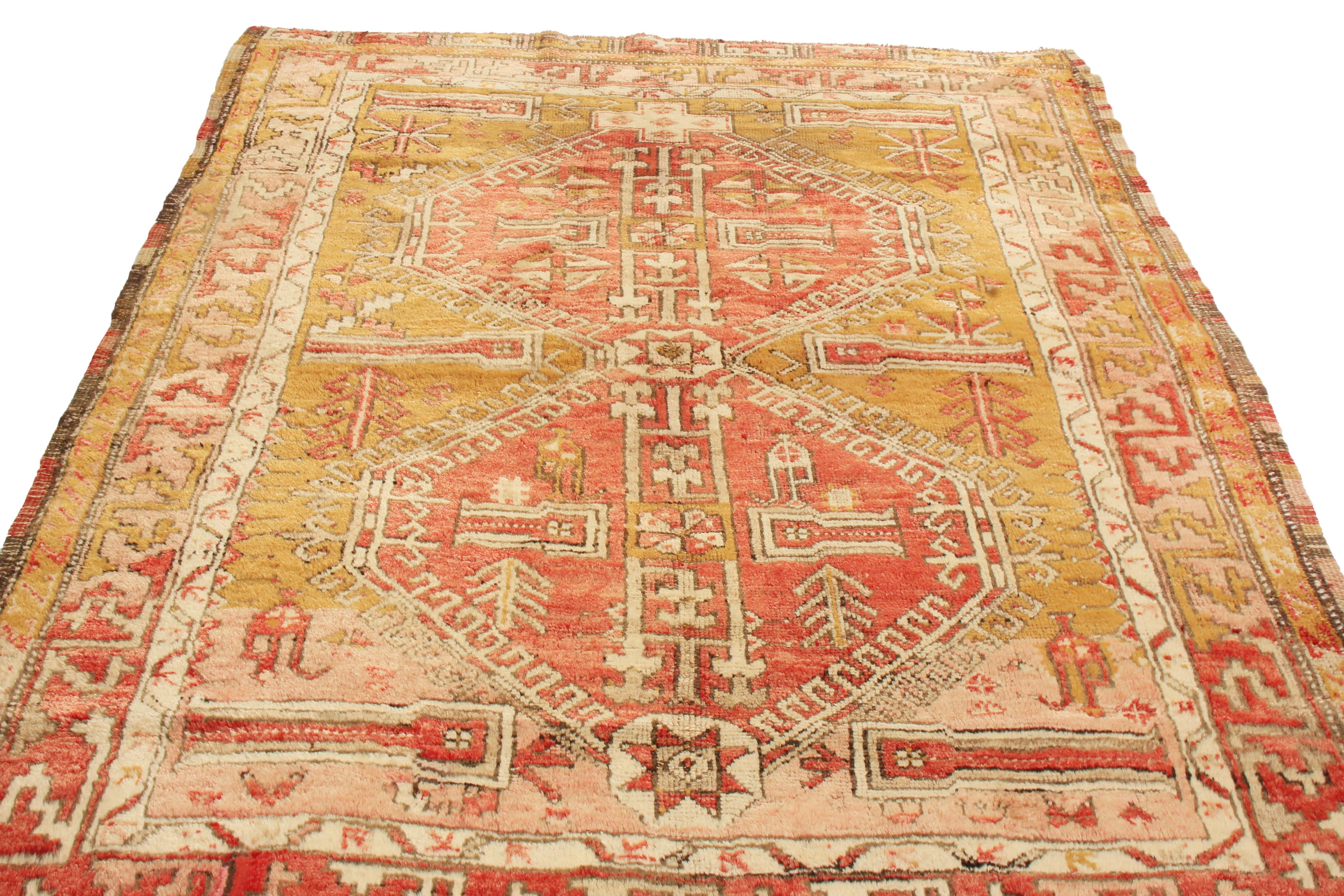 Originating from Turkey in 1910, this antique traditional Oushak wool rug was hand knotted in high quality wool with a variety of rejuvenating and maternal symbols. Woven in a pallet of rustic red and pink against a deep golden-yellow background,