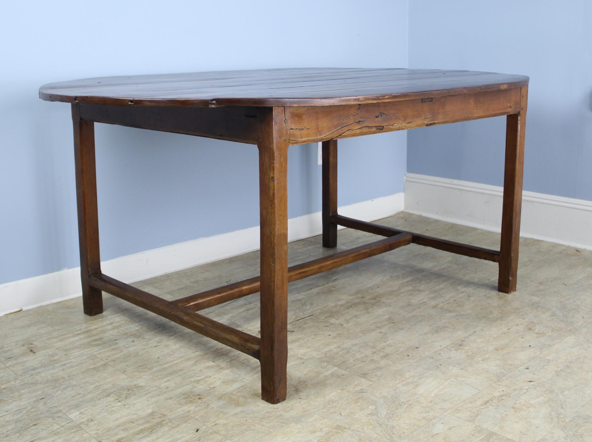 A generously proportioned oval table on a sturdy trestle base. With 43 inches between the legs on the long side, this table can seat six comfortably, eight in a pinch. Nicely hand planed planks and good color give this table real character. Some