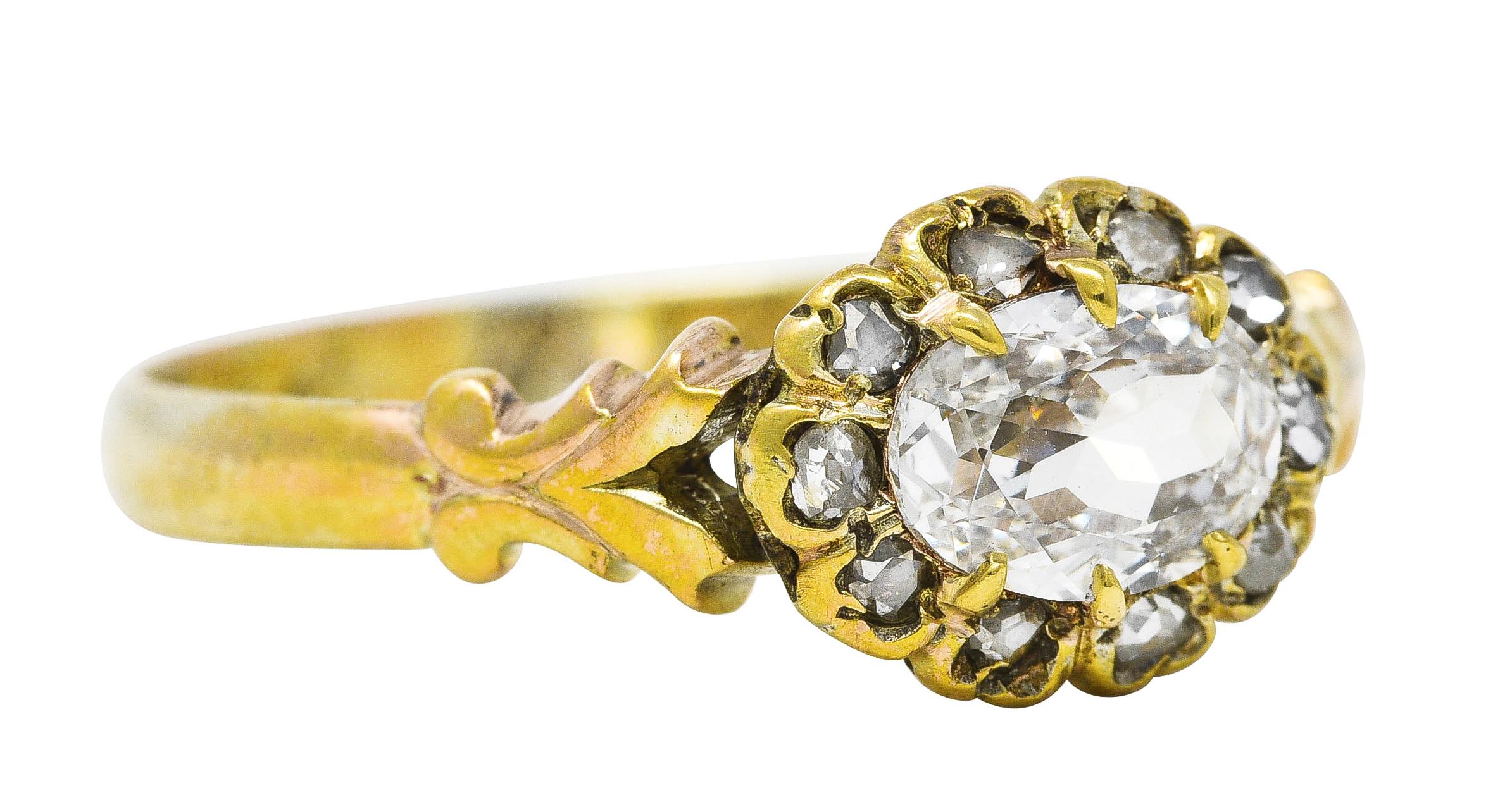 Cluster ring centers an oval cut diamond weighing 0.54 carat - G color with VS2 clarity. Talon set East to West and surrounded by a halo of rose cut diamonds. Weighing collectively approximately 0.10 carat - quality consistent with age and cut. Set