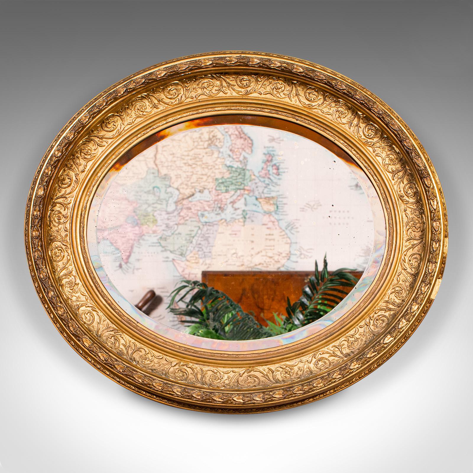 
This is an antique oval mirror. An English, giltwood overmantle or reception hall valet mirror, dating to the Georgian period, circa 1800.

Striking mirror with a fine Italianate appeal
Displays a desirable aged patina and in good order
Quality